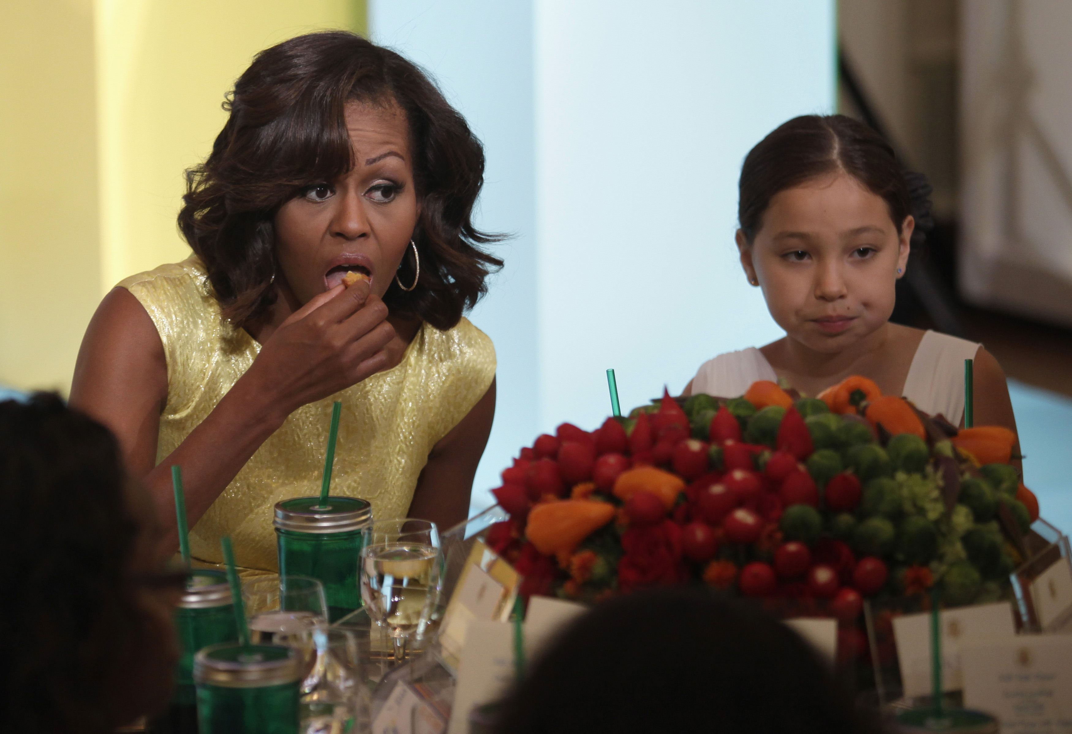 H Μισέλ Ομπαμα τρώει με όρεξη το ζαρζαβατικό της. Το κοριτσάκι δίπλα της; ΦΩΤΟ REUTERS