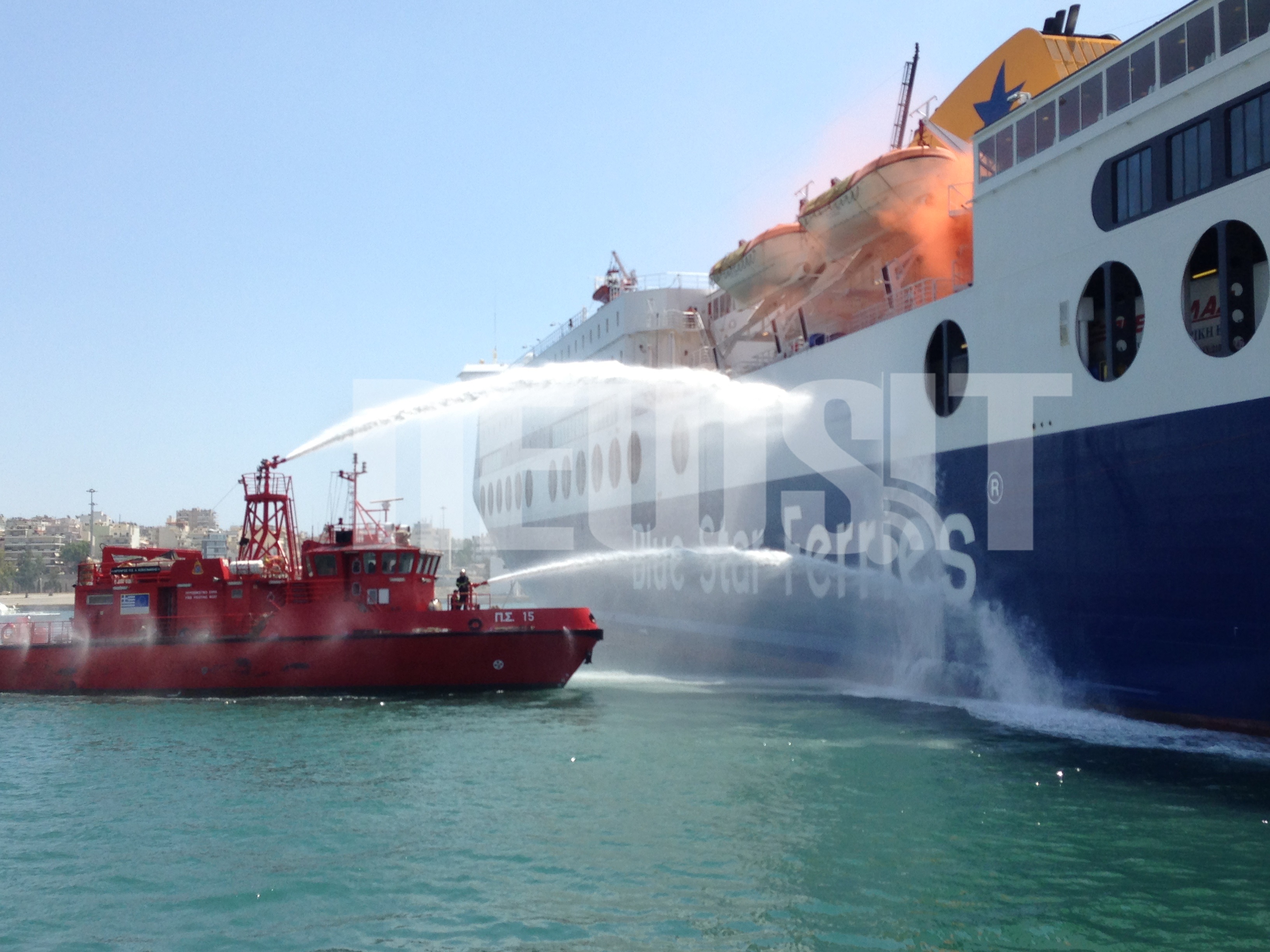 Το πυροσβεστικό σκάφος πραγματοποιείς ρίψεις νερού στο πλοίο στο πλαίσιο της άσκησης - ΦΩΤΟ NEWSIT 