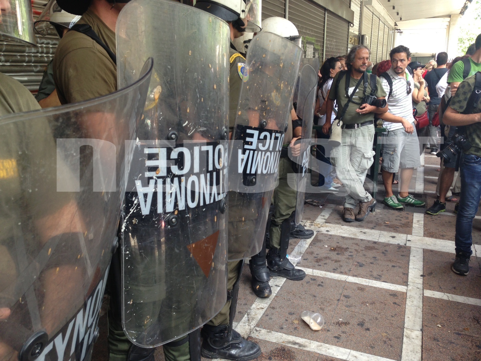 Οι διαμαρτυρόμενοι πέταξαν καφέδες και νερά εναντίων των ανδρών των ΜΑΤ ΦΩΤΟ NEWSIT