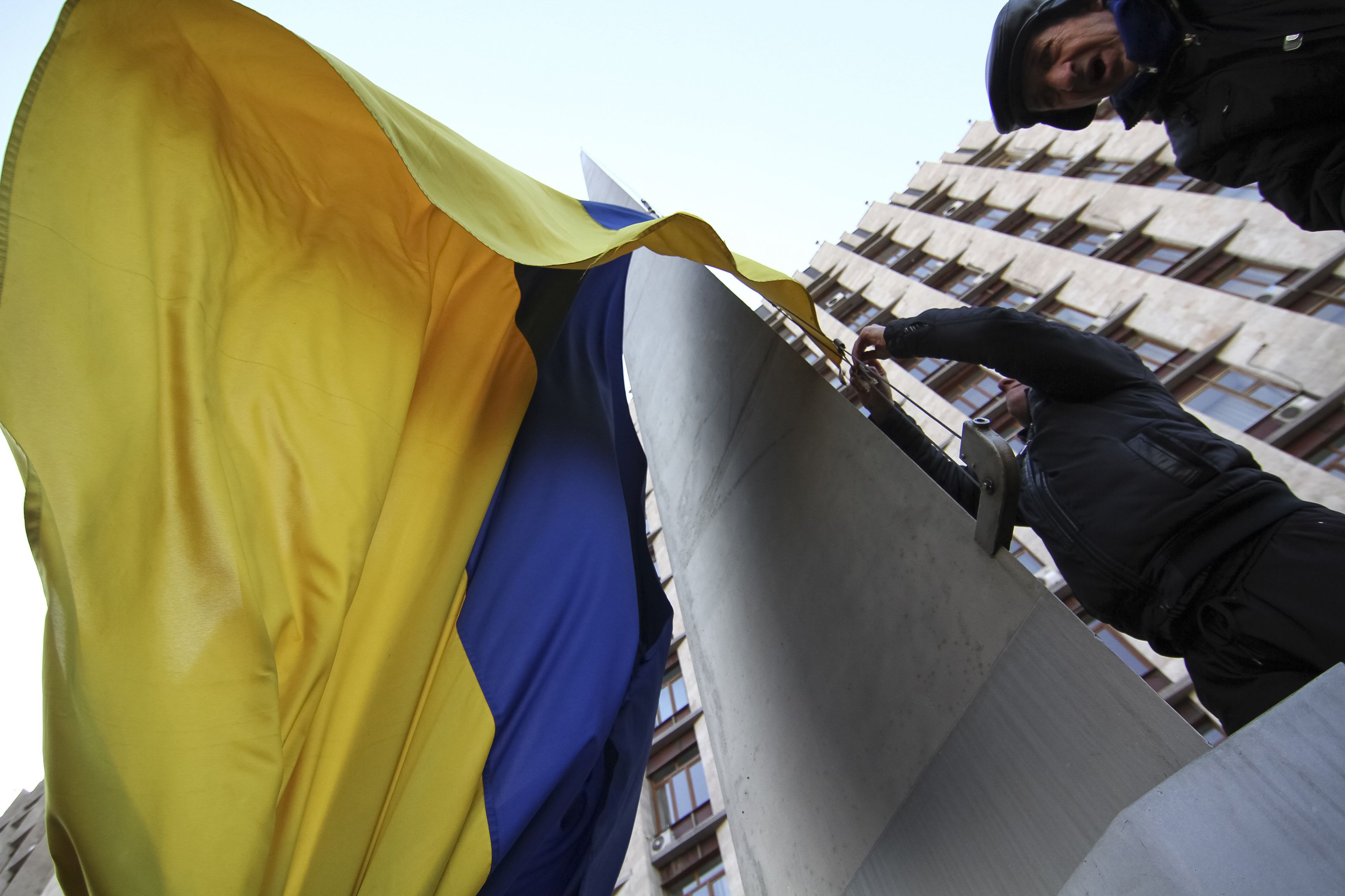 Φιλορώσος διαδηλωτής κατεβάζει την ουκρανική σημαία στην πόλη Ντόνετσκ - ΦΩΤΟ REUTERS