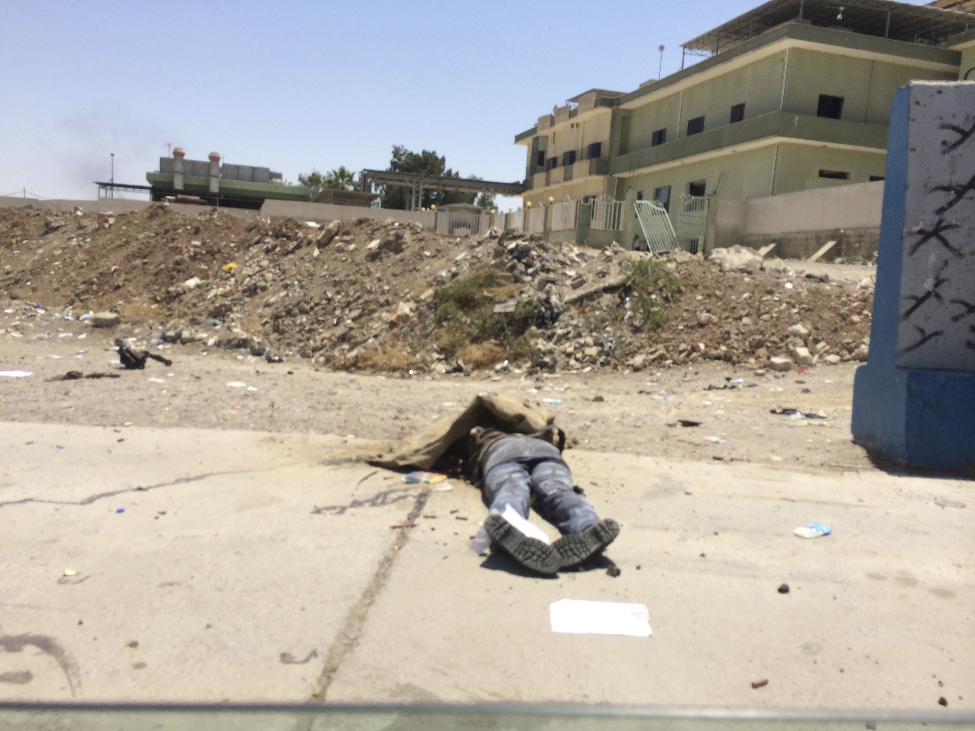Φωτό - Reuters - Ένα μέλος της Ιρακινής ασφάλειας κείτεται νεκρός μετά από την κατάληψη της Μοσούλης από τους αντάρτες
