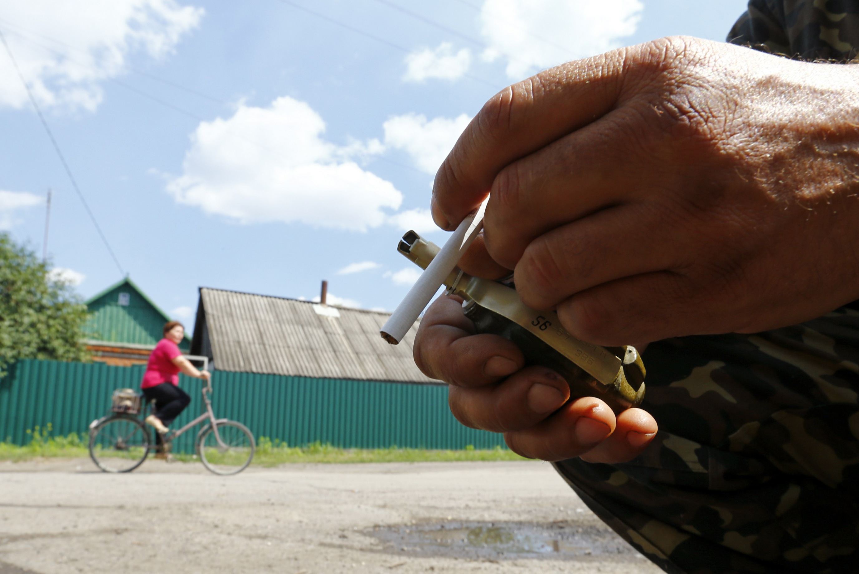 Τσιγάρο, χειροβομβίδα και γυναίκα με ποδήλατο το... σουρεαλιστικό σκηνικό στην ανατολική Ουκρανία - ΦΩΤΟ - Reuters