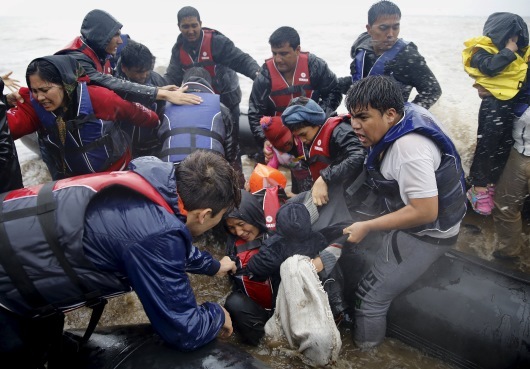 Με το μωρό στην αγκαλιά προσπαθεί να κατέβει από τη φουσκωτή βάρκα - ΦΩΤΟ REUTERS