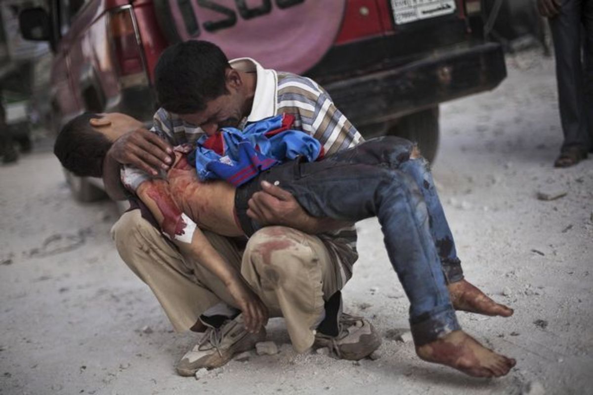Σύρος κρατά τον τραυματισμένο γιο του έξω από το νοσοκομείο Dar El Shifa στο Aleppo στις 3/11/12 - Το παιδί σκοτώθηκε από τον συριακό στρατό AP- Manu Brabo