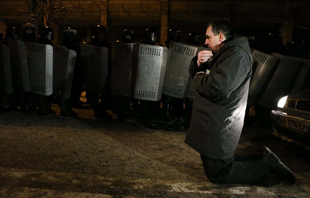 Κίεβο: Η προσευχή του διαδηλωτή μπροστά στα ΜΑΤ – Άγρια επεισόδια