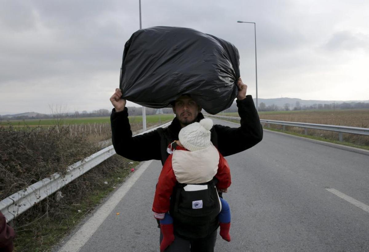 Πρόσφυγας με το μωρό του περπατάει προς τα σύνορα - ΦΩΤΟ REUTERS