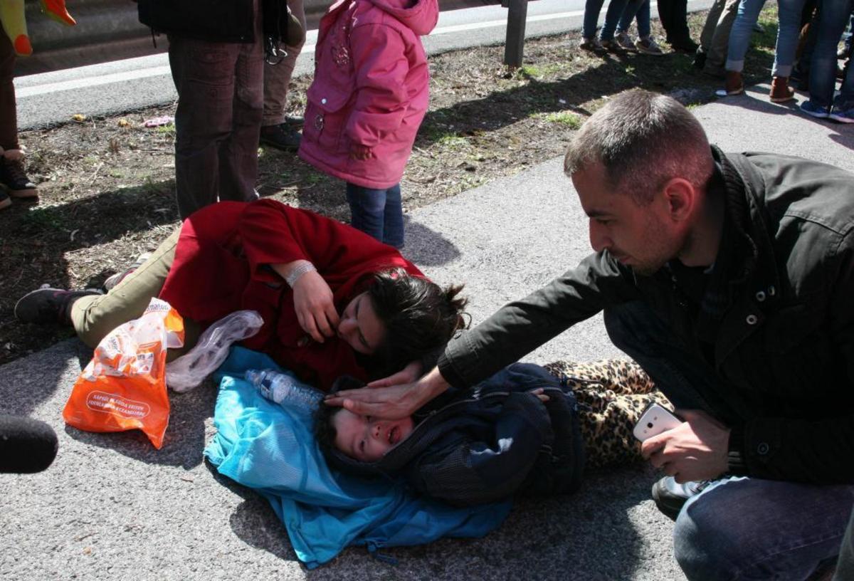 Εξαντλημένοι! Ένα παιδάκι ξάπλωσε στην άσφαλτο μαζί με μια γυναίκα- ΦΩΤΟ EUROKINISSI