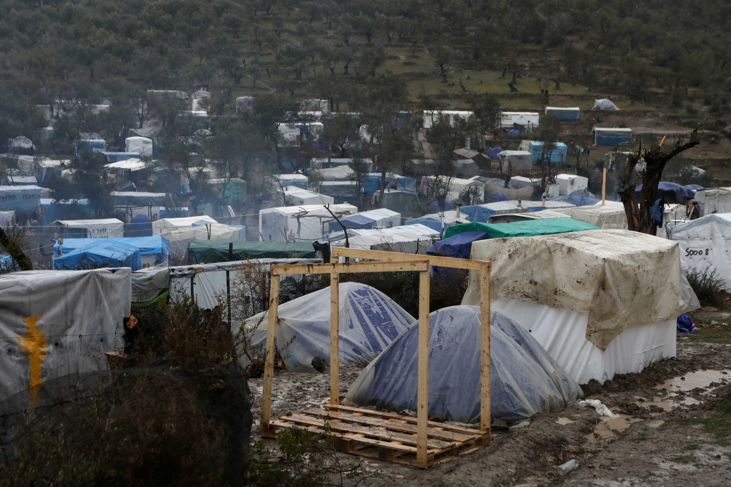 FILE PHOTO: A view of temporary camp for refugees and migrants next to the Moria camp during heavy rainfall on the island of Lesbos, Greece, February 6, 2020. REUTERS