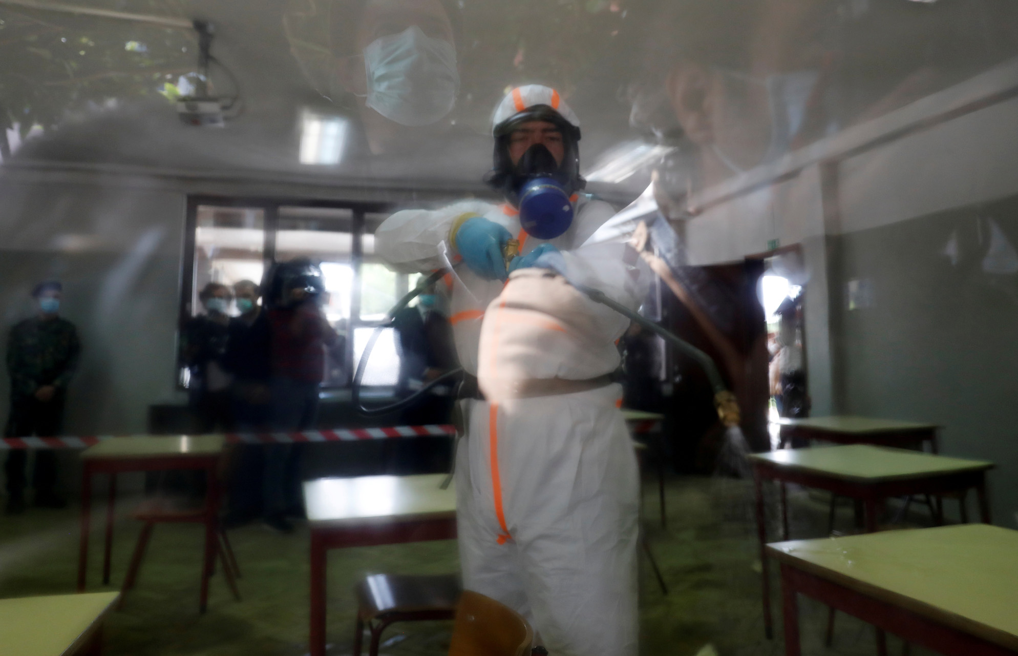 A Portuguese military police officer disinfects a school as part of a demonstration ahead of students' return as the spread of the coronavirus disease (COVID-19) continues, in Lisbon, Portugal April 29, 2020. REUTERS