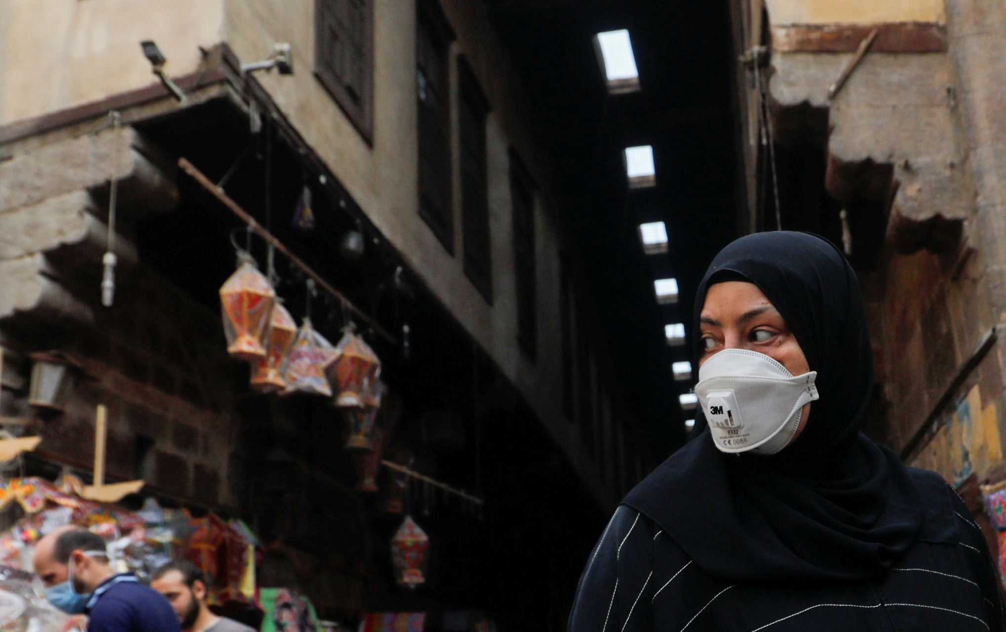 FILE PHOTO: A woman wearing a protective face mask, amid concerns over the coronavirus disease (COVID-19), looks at traditional Ramadan lanterns, called "Fanous" which are displayed for sale at a stall, ahead of the Muslim holy month of Ramadan at Al Khayamia street in old Cairo, Egypt April 16, 2020. REUTERS