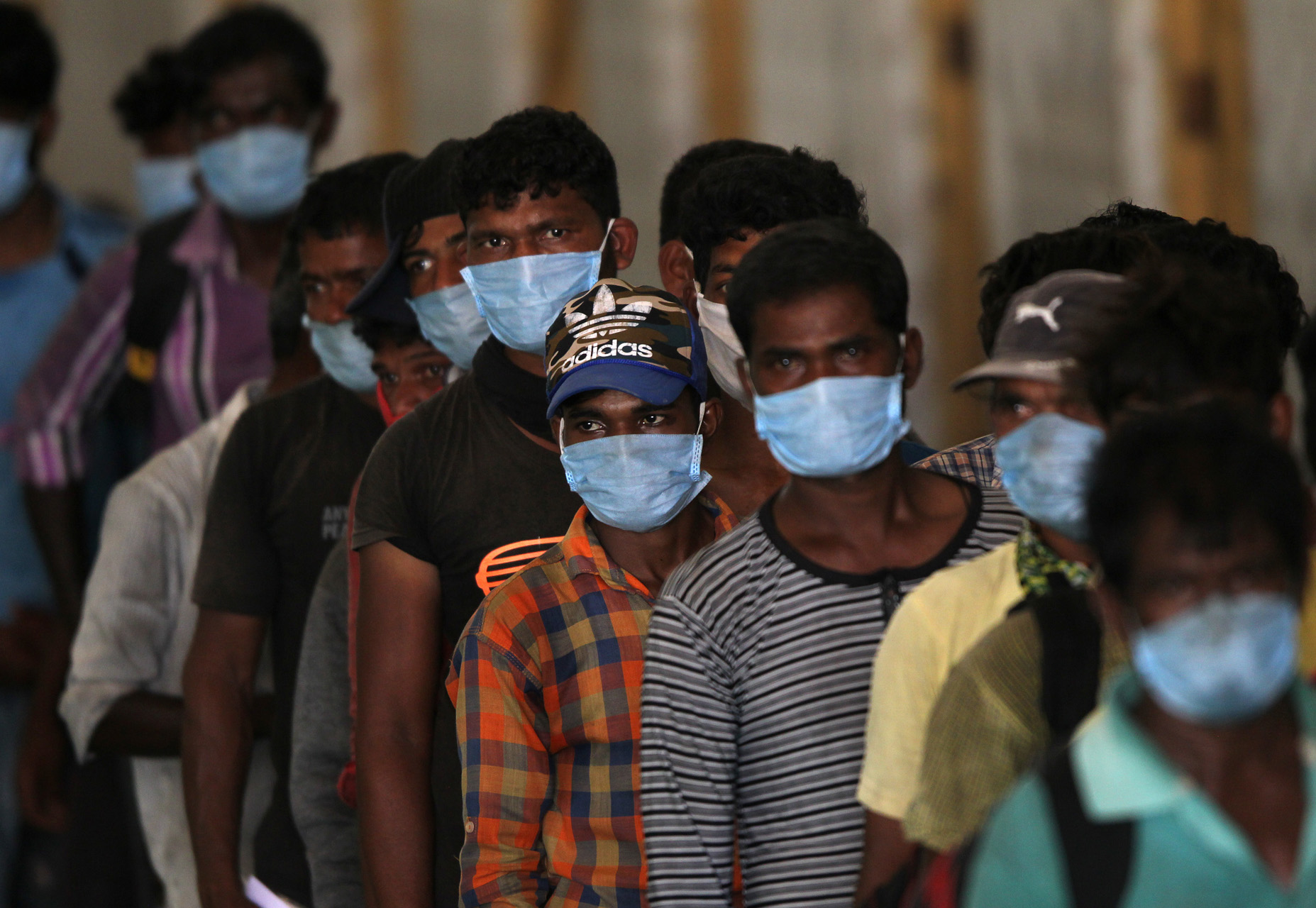 Indian fishermen, who said they were refused entry at two ports after a nationwide lockdown was imposed to fight the coronavirus disease (COVID-19), wait to get their health checkup after they disembarked from their boats after travelling in the Arabian Sea to reach to their home state Maharashtra from the western state of Gujarat, in Dahanu in Palghar district in Maharashtra, India, April 17, 2020. REUTERS