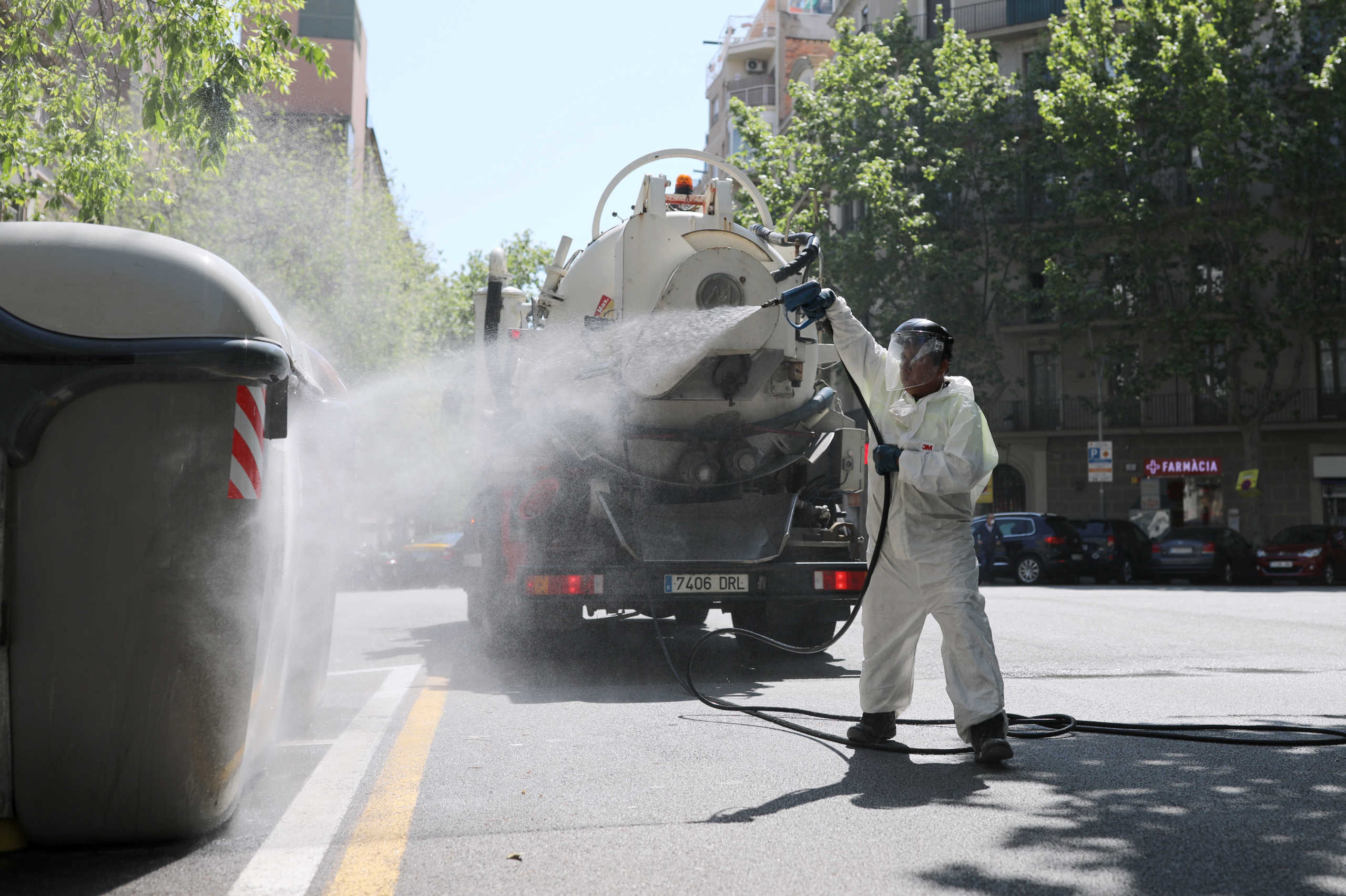 A worker disinfects garbage bins, following the coronavirus disease (COVID-19) outbreak in Barcelona, Spain April 14, 2020. REUTERS