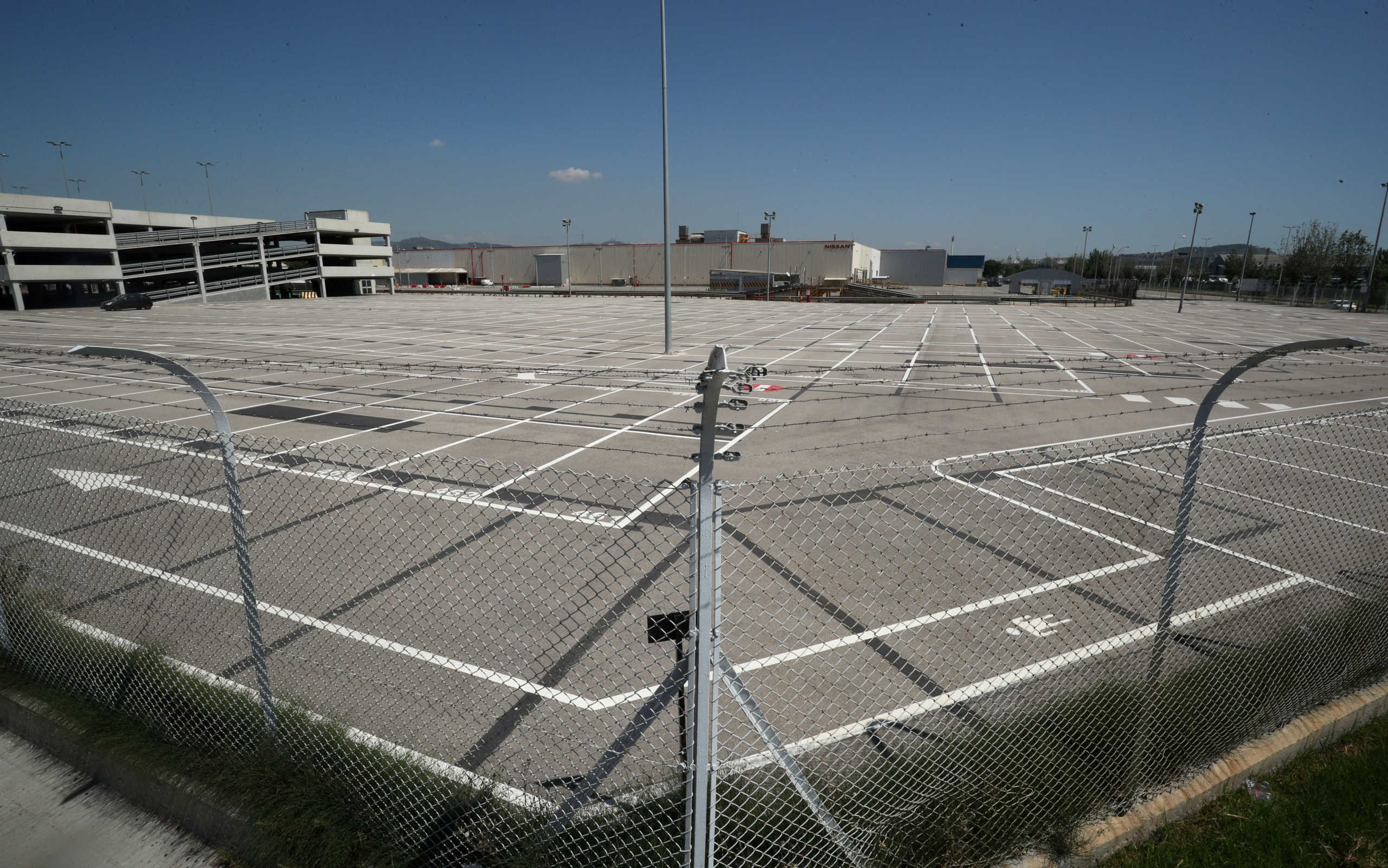 An empty parking lot is seen through a fence at Nissan factory at Zona Franca during the coronavirus disease (COVID-19) outbreak in Barcelona, Spain, May 26, 2020. REUTERS