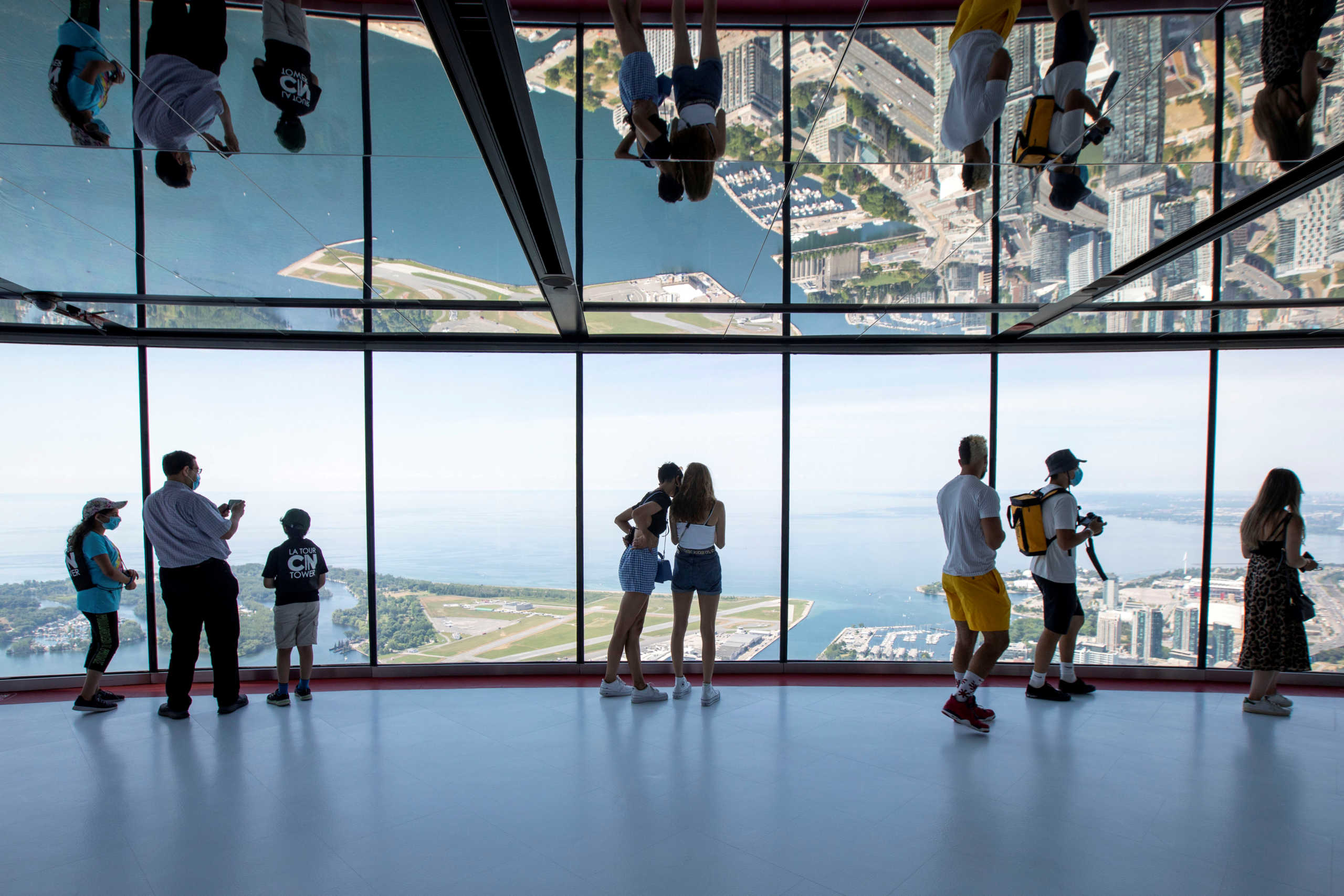 FILE PHOTO: Visitors view panoramic city scenes from the 553 metres (1815 feet) high CN Tower, which reopened for the first time since the coronavirus disease (COVID-19) restrictions were imposed in Toronto, Ontario, Canada July 15, 2020. REUTERS