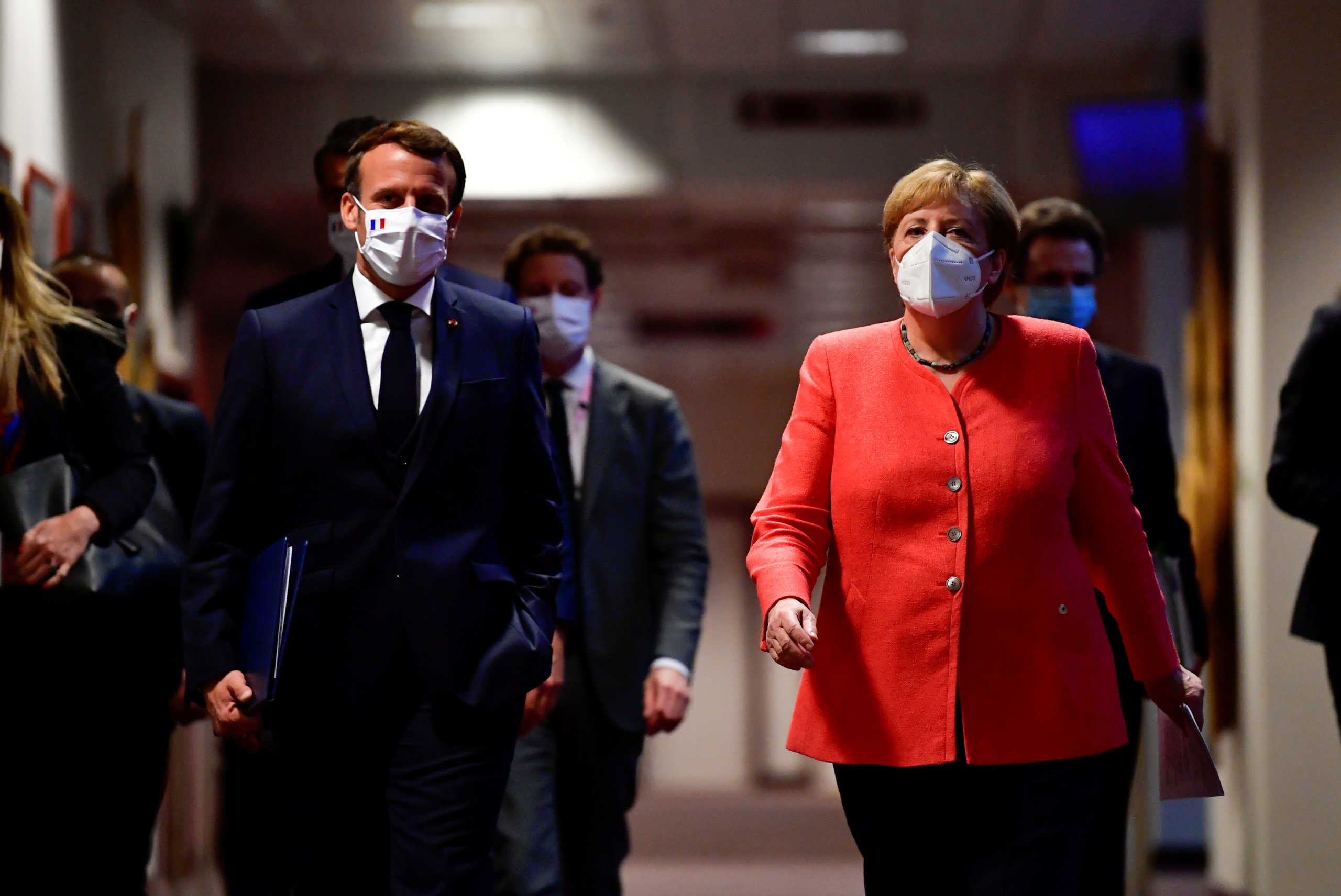 FILE PHOTO: German Chancellor Angela Merkel (R) and French President Emmanuel Macron (L) arrive for a joint press conference at the end of the European summit at the EU headquarters in Brussels on July 21, 2020. John Thys