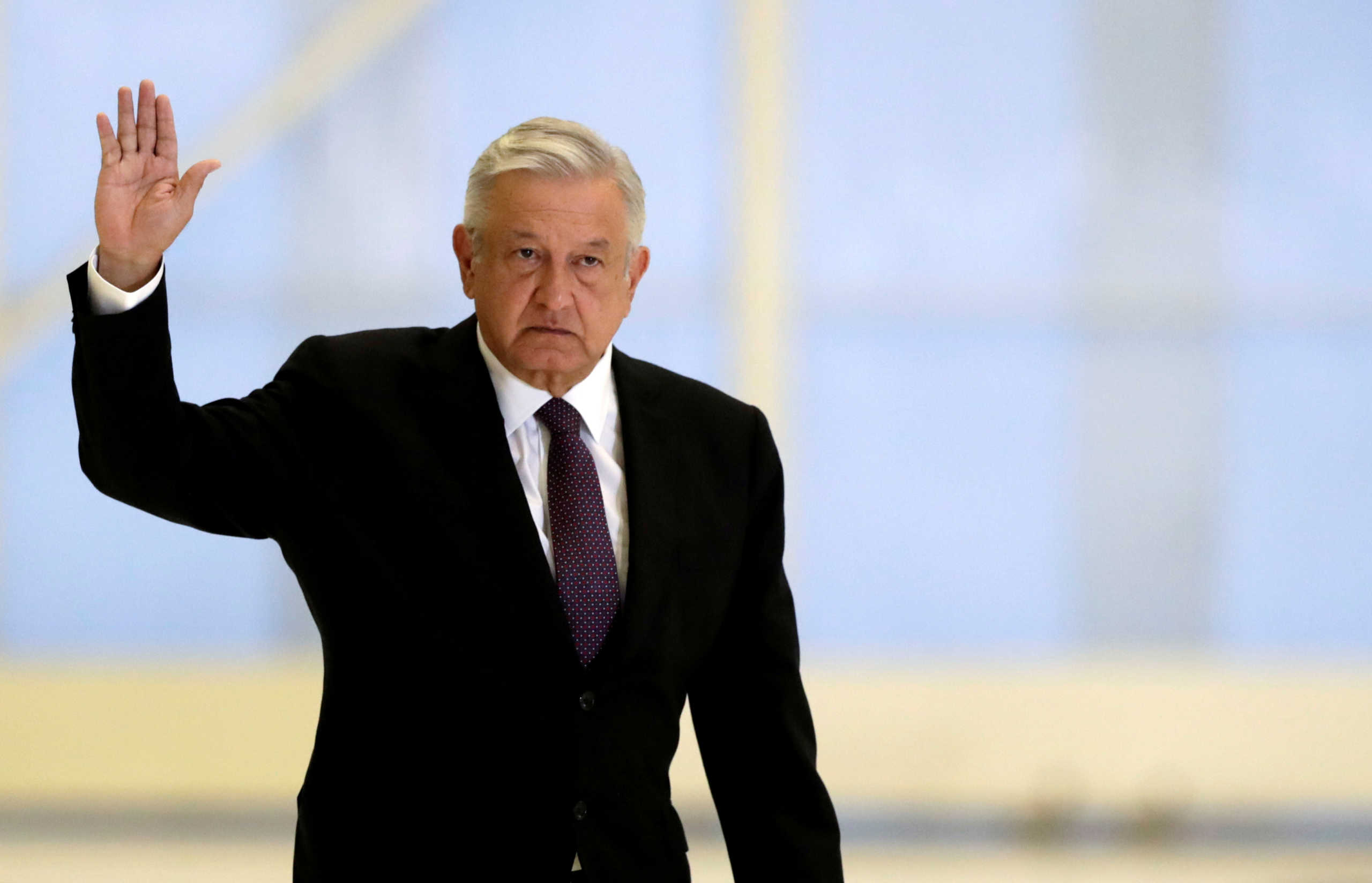 FILE PHOTO: Mexico's President Andres Manuel Lopez Obrador waves as he arrives to hold a news conference at the presidential hangar, with the presidential plane in the background, at Benito Juarez International Airport in Mexico City, Mexico July 27, 2020. REUTERS