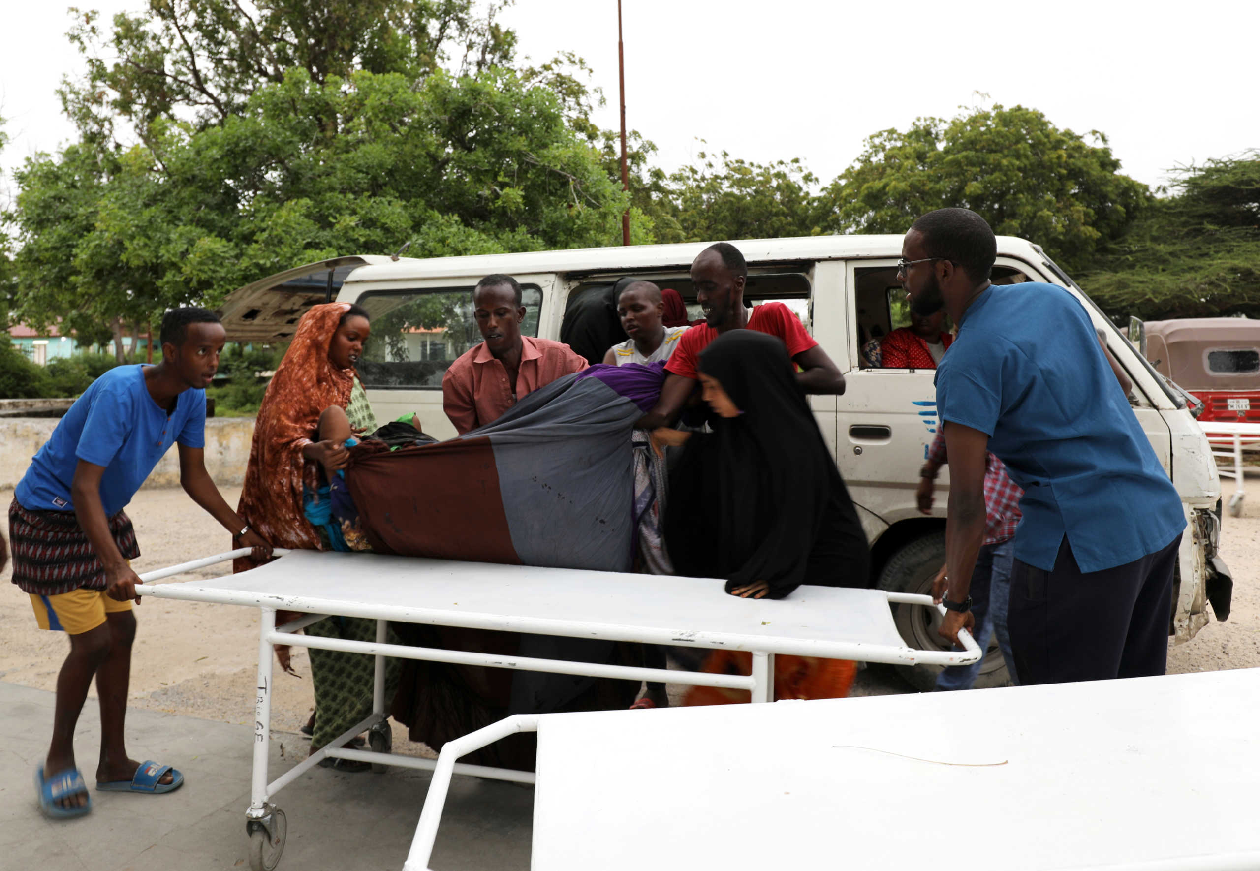 Civilians assist an injured person at Madina hospital after a blast at the Elite Hotel in Lido beach in Mogadishu, Somalia August 16, 2020. REUTERS