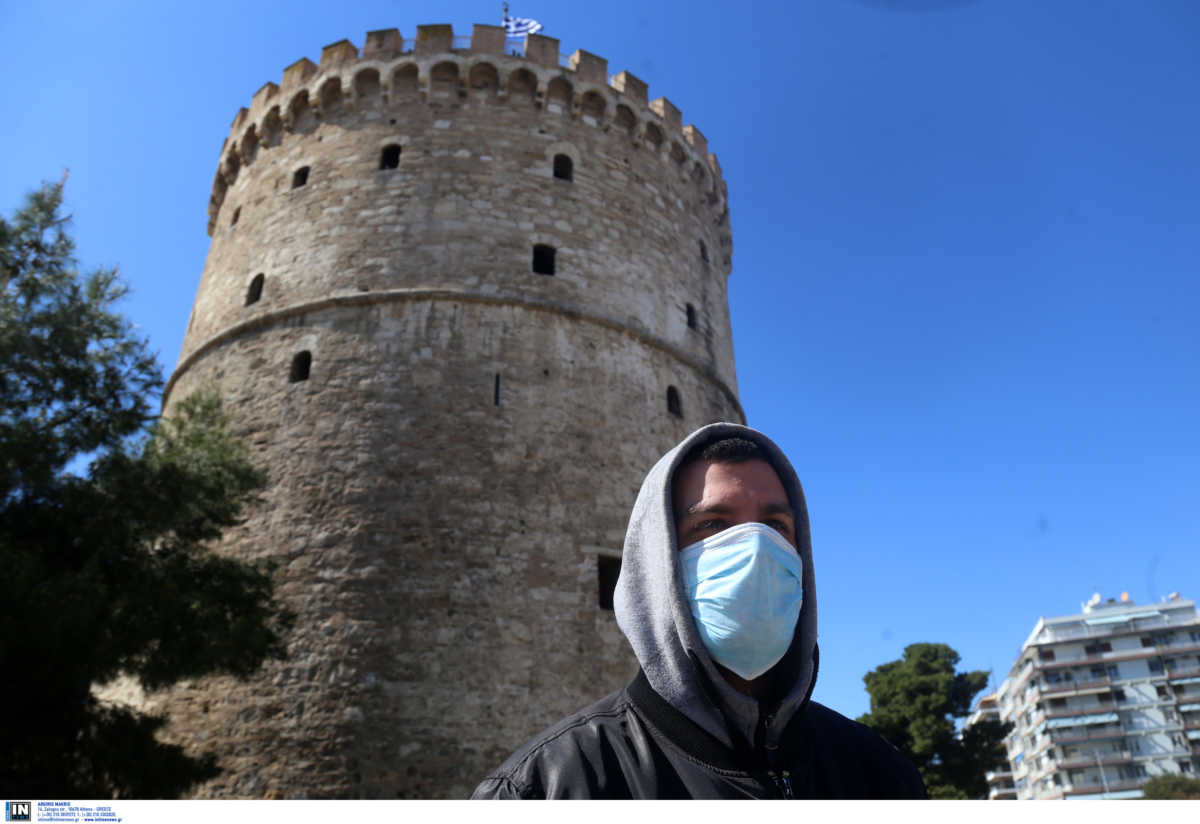 Νεαρός με μάσκα μπροστά από τον Λευκό Πύργο στη Θεσσαλονίκη