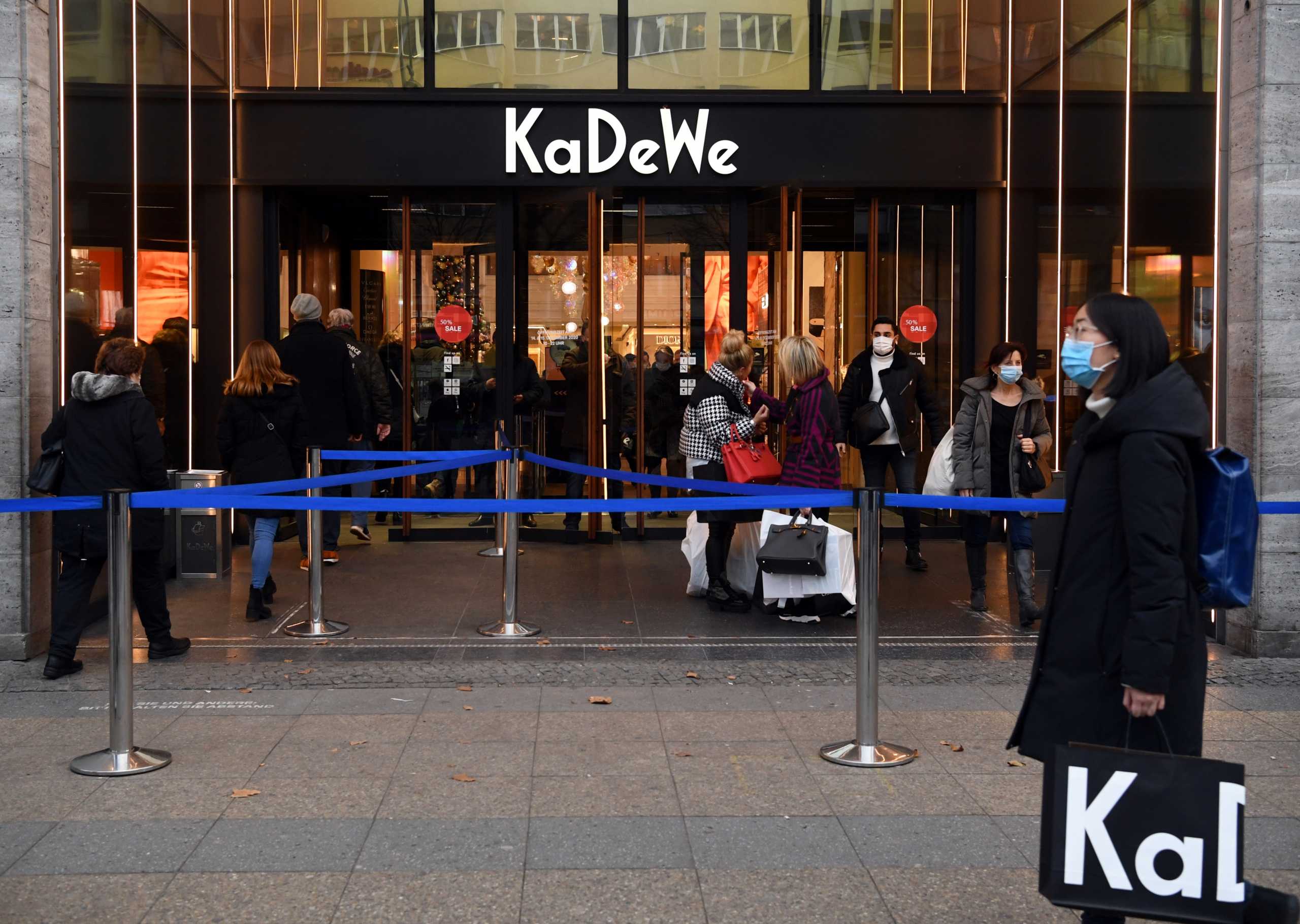 People wearing protective face masks enter the KaDeWe, the department store, before Germany goes back to a nationwide hard lockdown due to the coronavirus disease (COVID-19) outbreak, in Berlin, Germany, December 15, 2020.  REUTERS