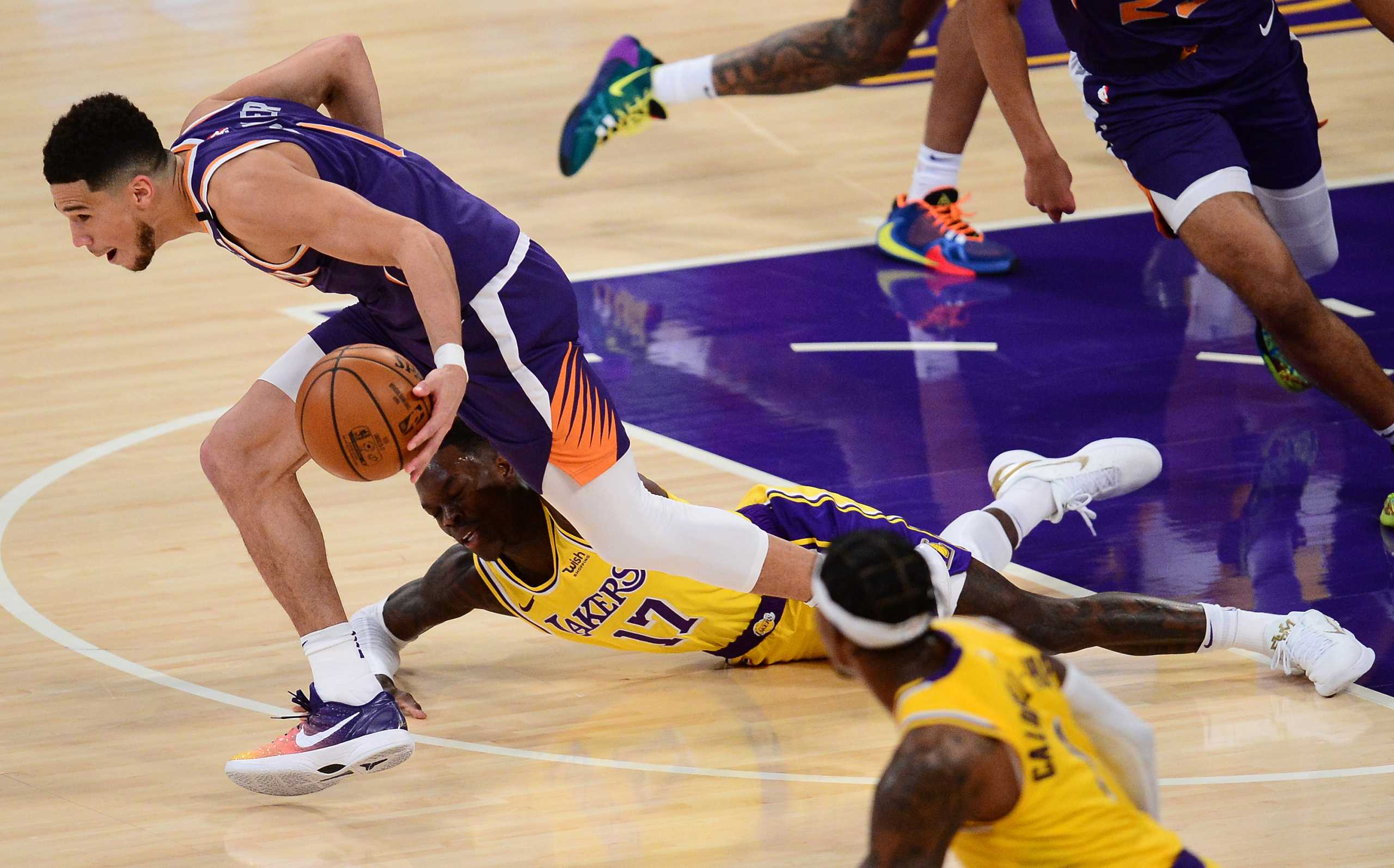 Mar 2, 2021; Los Angeles, California, USA; Phoenix Suns guard Devin Booker (1) moves the ball off of a turnover by Los Angeles Lakers guard Dennis Schroder (17) during the first half at Staples Center. Mandatory Credit: Gary A. Vasquez-USA TODAY Sports