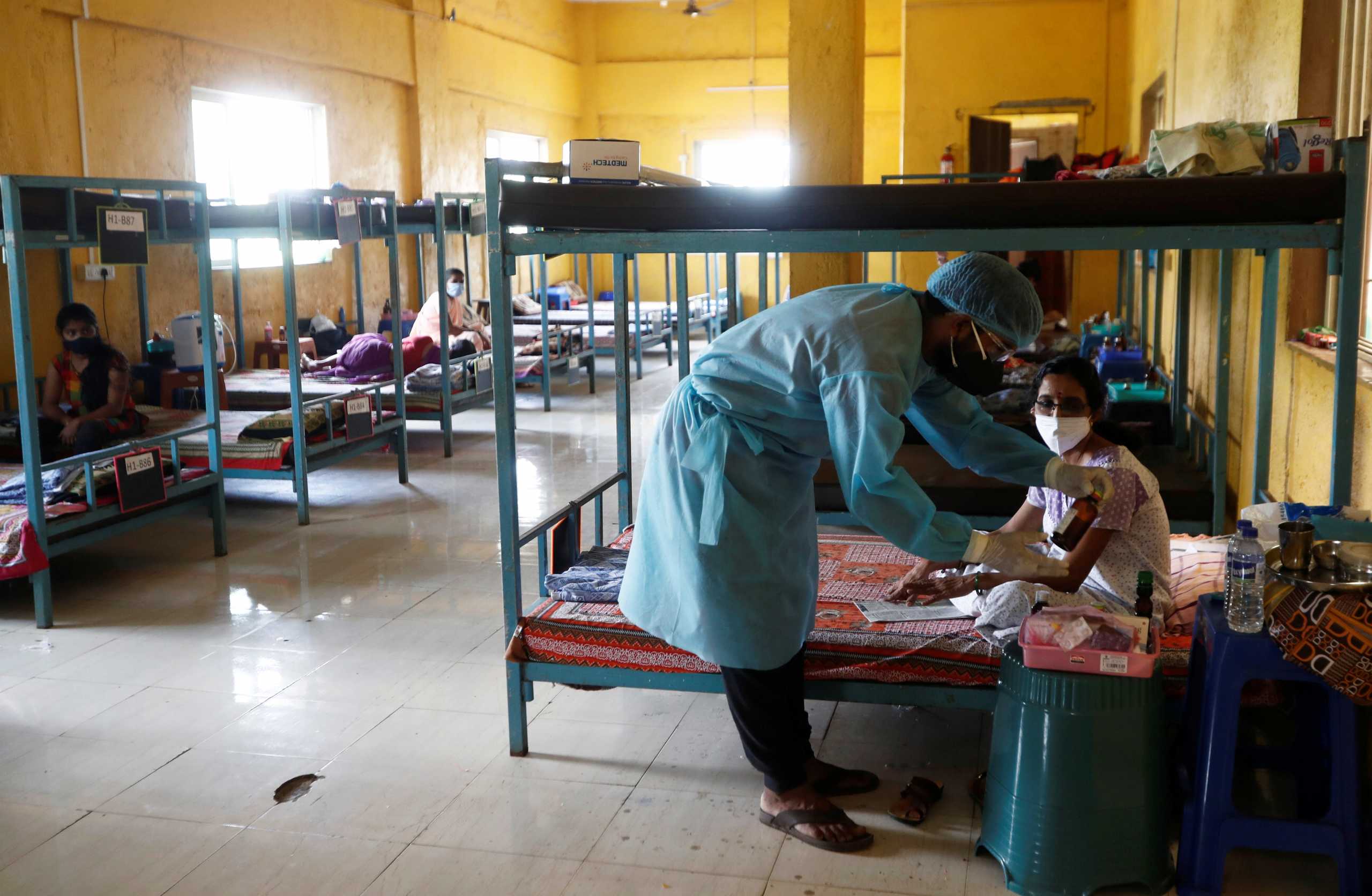 A doctor checks the medicines of a patient suffering from coronavirus disease (COVID-19) inside a classroom turned COVID-19 care facility on the outskirts of Mumbai, India, May 24, 2021. REUTERS