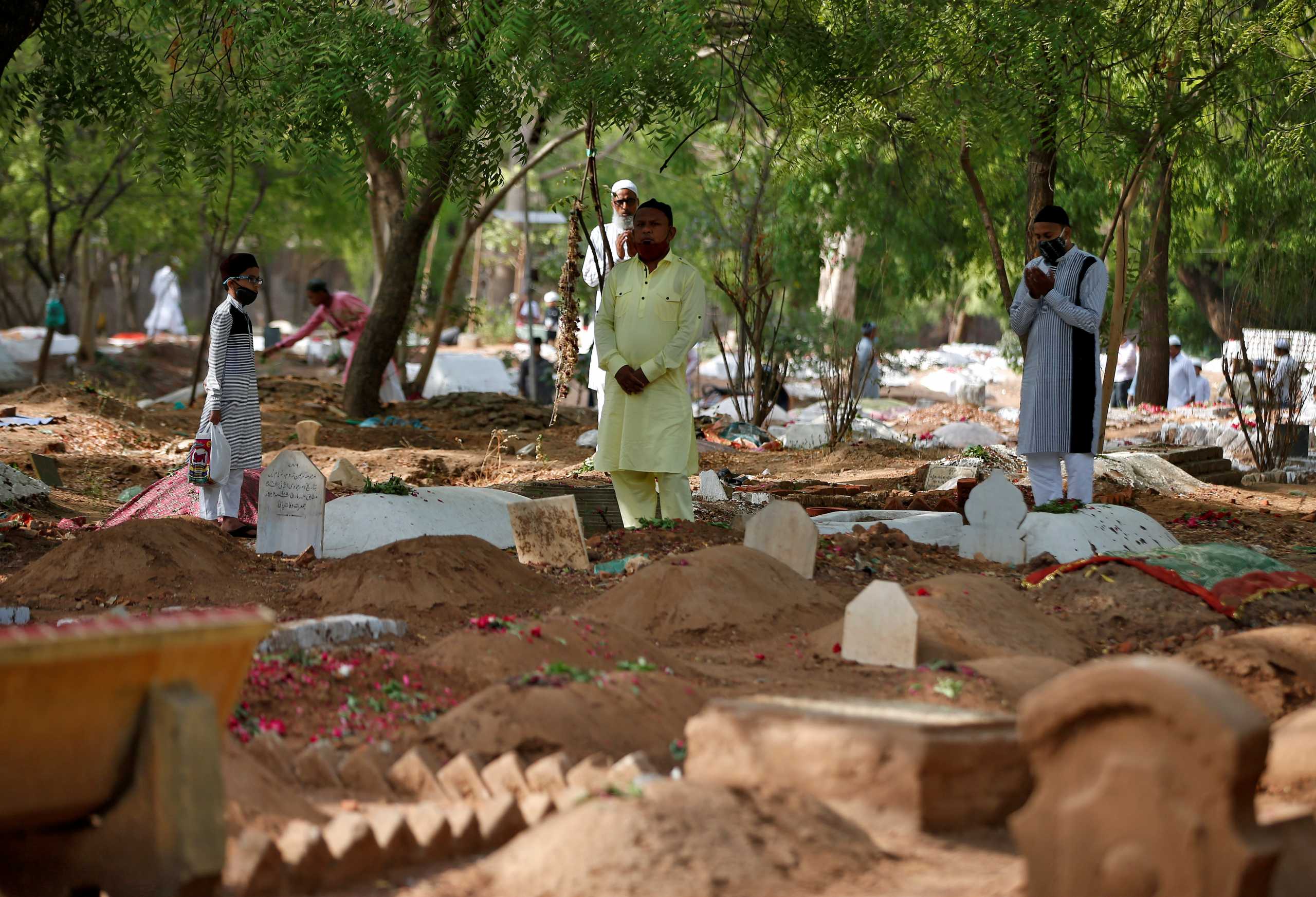 Muslims pray next to the graves of their relatives including those who died from the coronavirus disease (COVID-19), on the occasion of the Eid al-Fitr amidst the spread of the disease in Ahmedabad, India, May 14, 2021. REUTERS