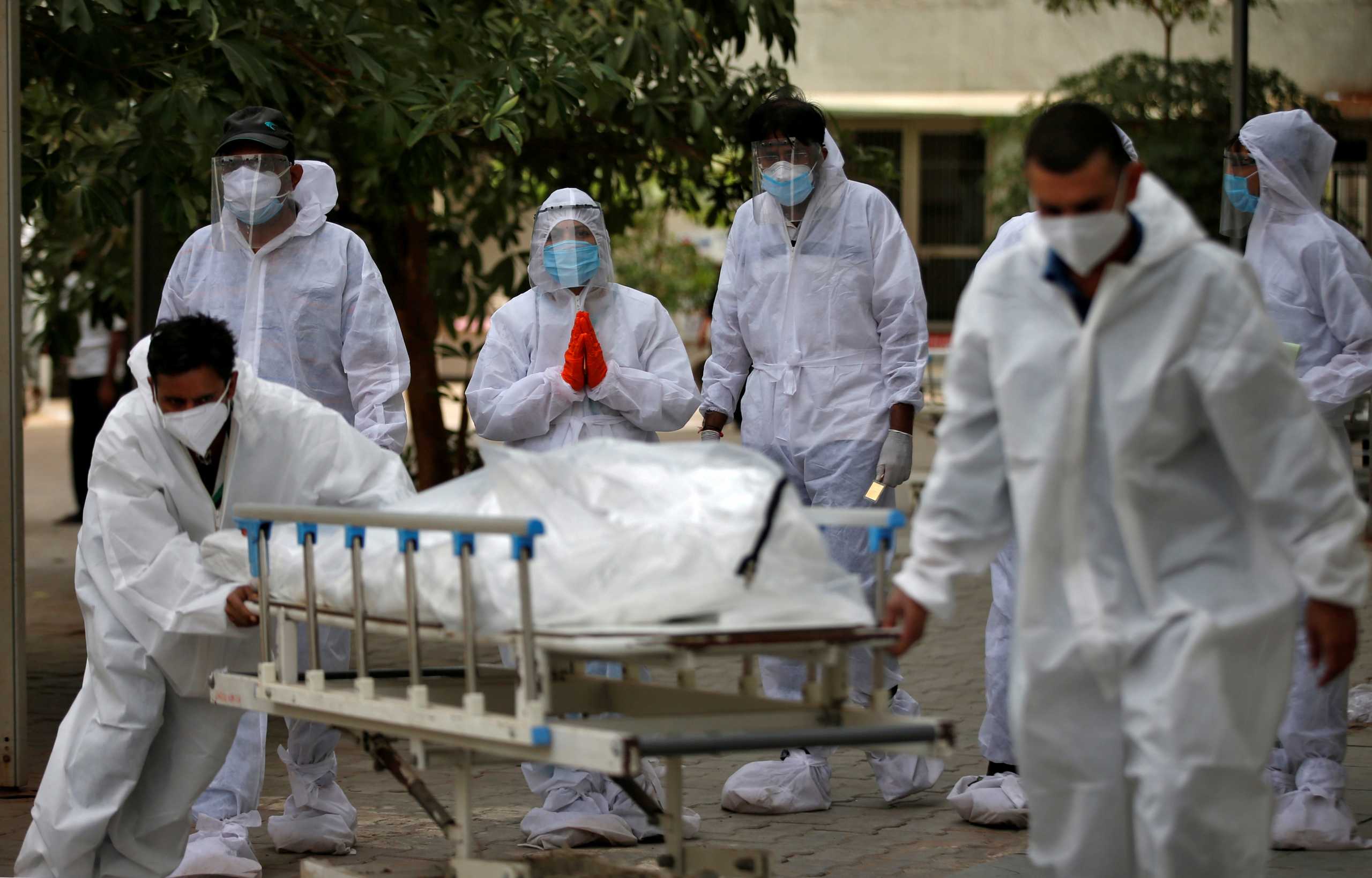 Relatives react as healthcare workers pull a stretcher carrying the body of a person who died from the coronavirus disease (COVID-19), at a mortuary in Ahmedabad, India, May 8, 2021. REUTERS