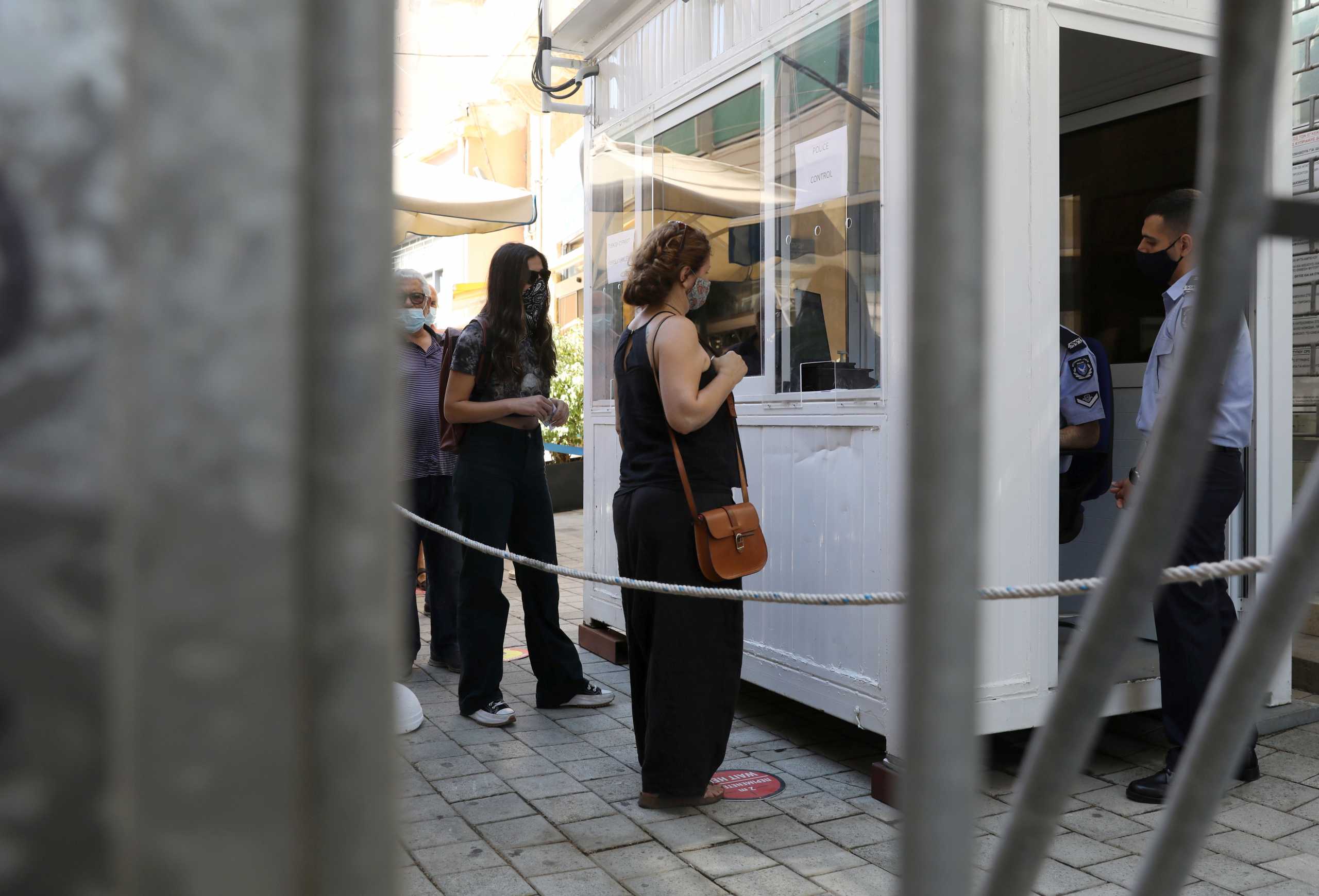 People wearing protective face masks cross Ledra's checkpoint of the U.N.-controlled buffer zone in Nicosia,  Cyprus June 4, 2021. REUTERS