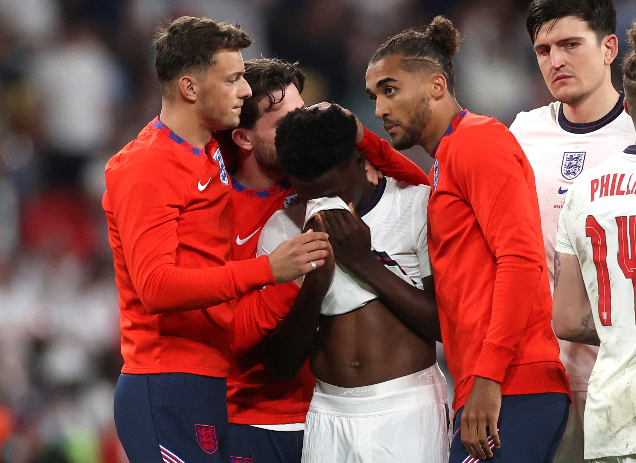 Soccer Football - Euro 2020 - Final - Italy v England - Wembley Stadium, London, Britain - July 11, 2021 England's Bukayo Saka looks dejected after losing the penalty shootout as teammates console him Pool via REUTERS