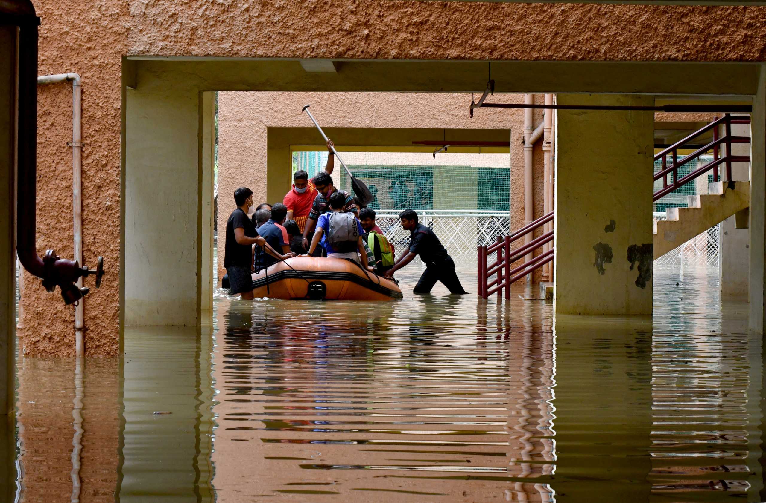 Members of National Disaster Response Force (NDRF) move residents to safer places after heavy rains caused flooding in a residential area in Bengaluru, India, November 22, 2021. REUTERS