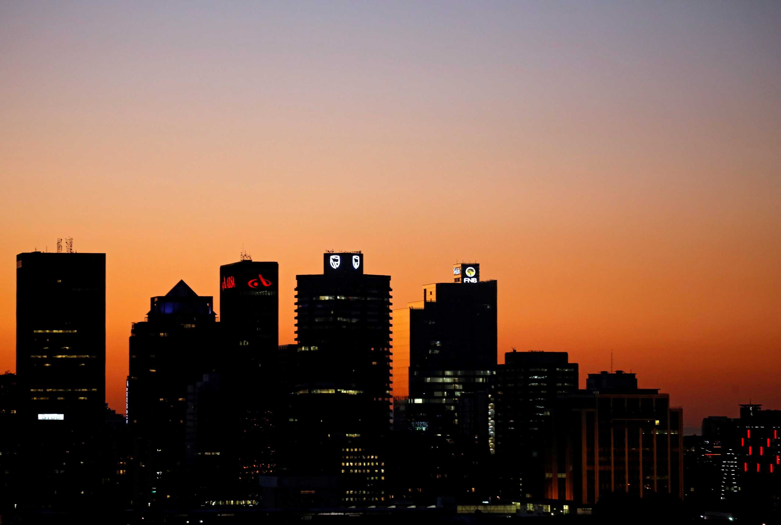 FILE PHOTO: The buildings with the logos of three of South Africa's biggest banks, ABSA, Standard Bank and First National Bank (FNB) are seen against the city skyline in Cape Town, South Africa, September 3, 2017. REUTERS