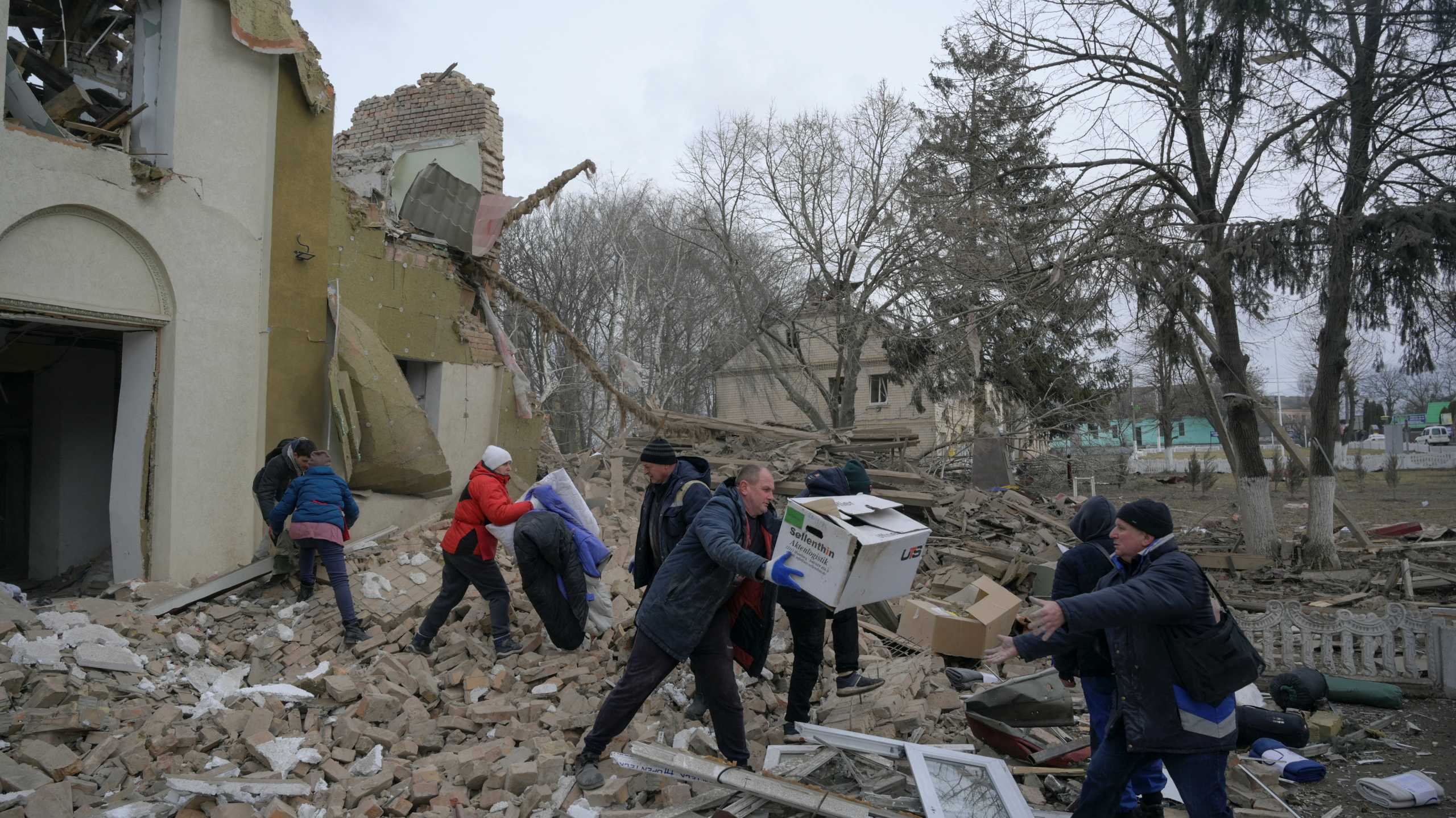 Local residents gather humanitarian aid stored at a cultural and community centre, which locals said was destroyed by recent shelling, as Russia's invasion of Ukraine continues, in the settlement of Byshiv in the Kyiv region, Ukraine March 4, 2022. REUTERS