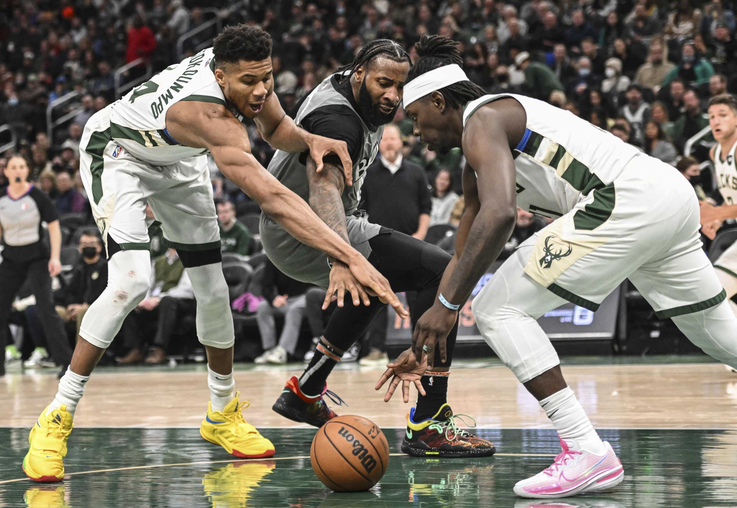 Feb 26, 2022; Milwaukee, Wisconsin, USA;  Milwaukee Bucks forward Giannis Antetokounmpo (34) and guard Jrue Holiday (21) reach for a loose ball against Brooklyn Nets center Andre Drummond (0) in the third quarter at Fiserv Forum. Mandatory Credit: Benny Sieu-USA TODAY Sports