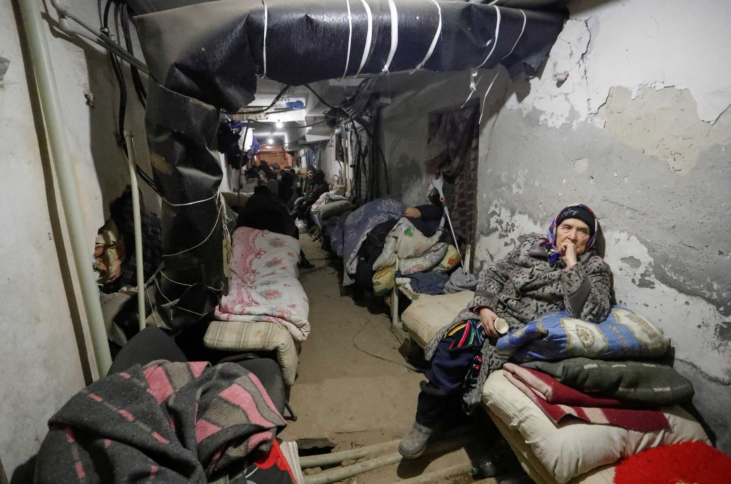 People gather in the basement of a local hospital, which was damaged during Ukraine-Russia conflict in the separatist-controlled town of Volnovakha in the Donetsk region, Ukraine March 12, 2022. REUTERS