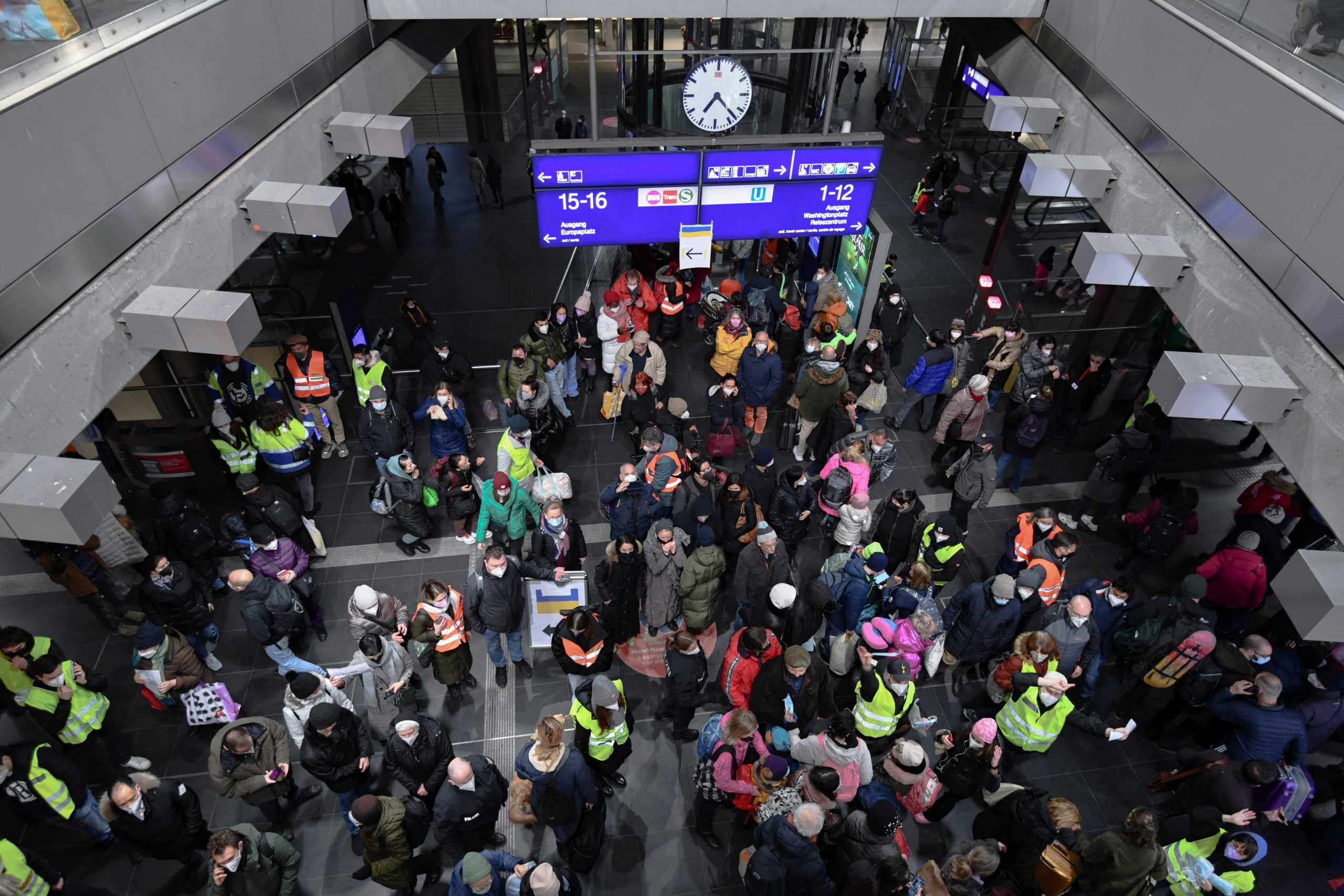 Volunteers in high-visibility clothing help refugees fleeing Russia's invasion of Ukraine who have arrived on a train from Poland at the central station in Berlin, Germany, March 6, 2022. REUTERS