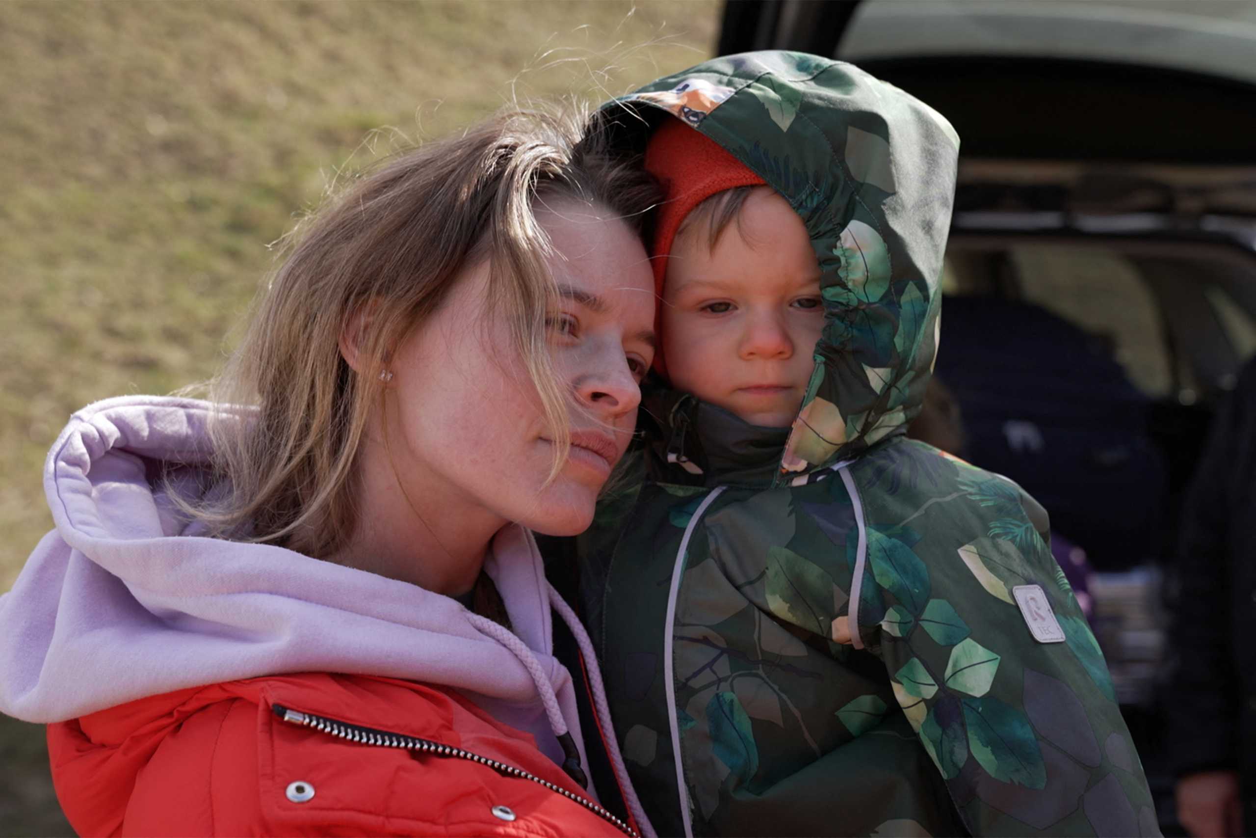 Svetlana, 28, a Ukrainian woman from Kyiv, holds her son Semyon as they arrive at the Hungarian border village of Tiszabecs, Hungary March 1, 2022 in this still image taken from a video. Gergely Papai