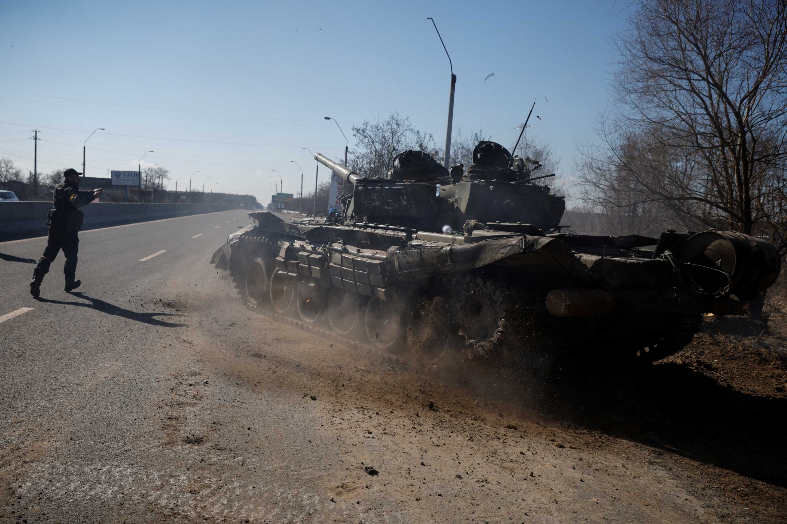 A Ukrainian soldier directs a Russian tank that Ukrainians captured after fighting with Russian troops, as Russia's attack on Ukraine continues, outside Brovary, near Kyiv, Ukraine, March 10, 2022. REUTERS