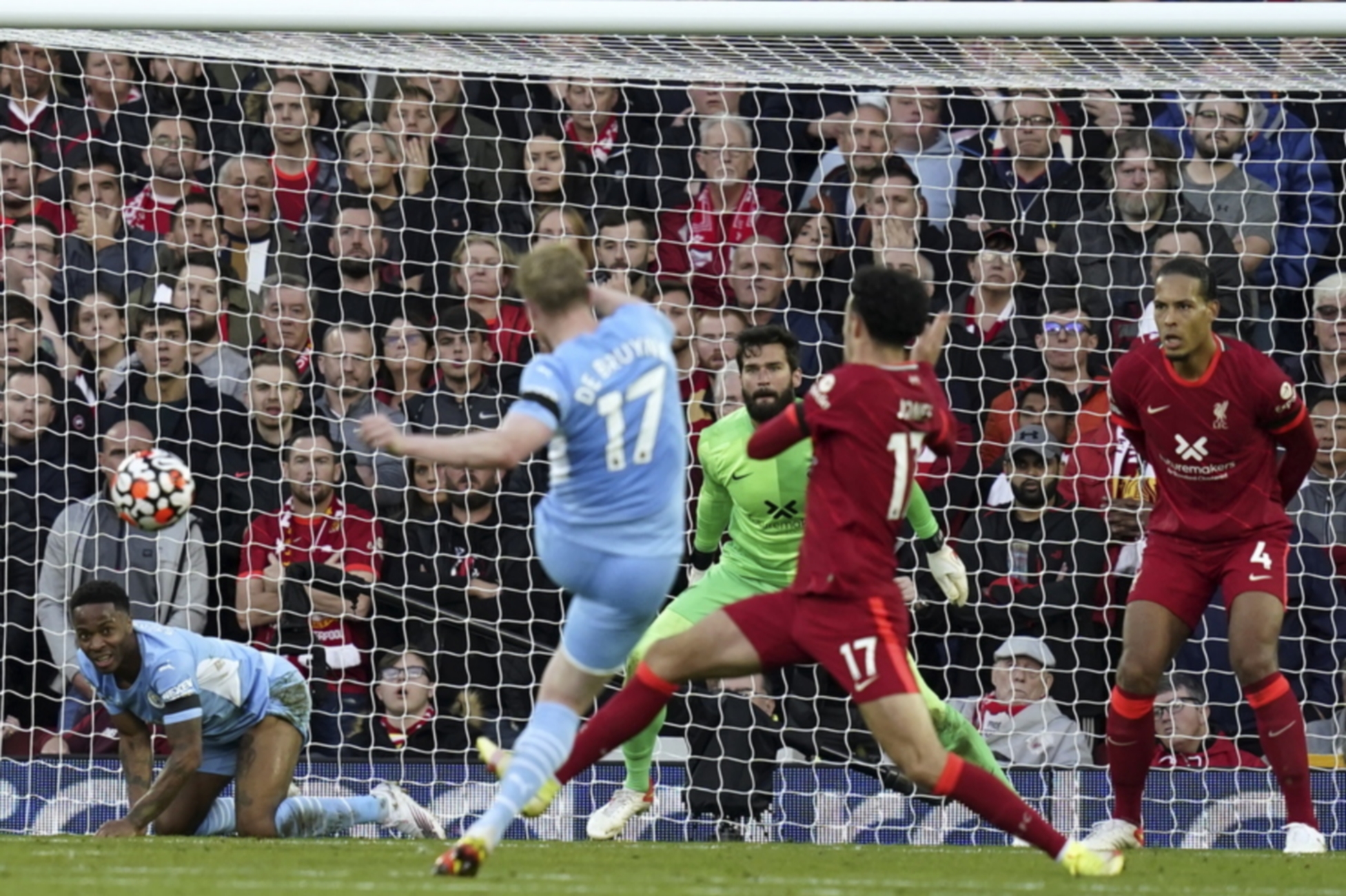 epa09504210 Kevin De Bruyne (C-L) of Manchester City scores the 2-2 equalizer against Liverpool's goalkeeper Alisson (back C) during the English Premier League soccer match between Liverpool FC and Manchester City in Liverpool, Britain, 03 October 2021.  EPA