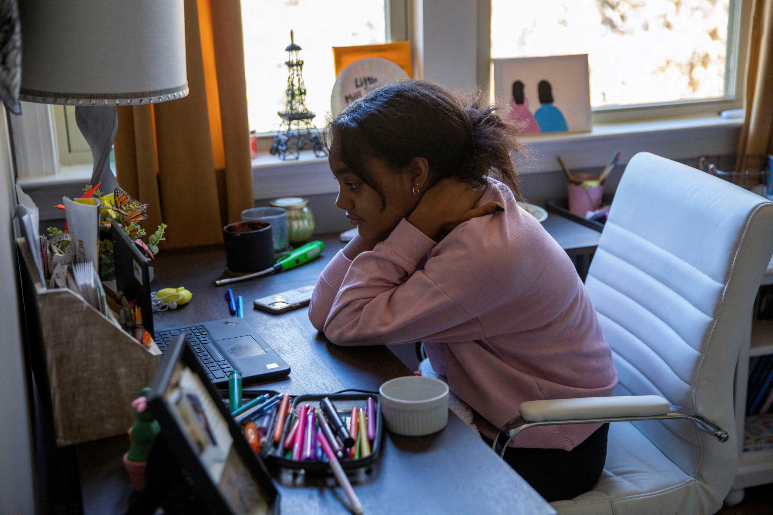 FILE PHOTO: Fulton County Public Schools 8th grader Ceani Williams participates in an online class during a virtual learning day at a desk in her bedroom in Milton, Georgia, U.S., January 4, 2022, after students have gone remote for a week as cases of the Omicron coronavirus variant continue to surge. REUTERS