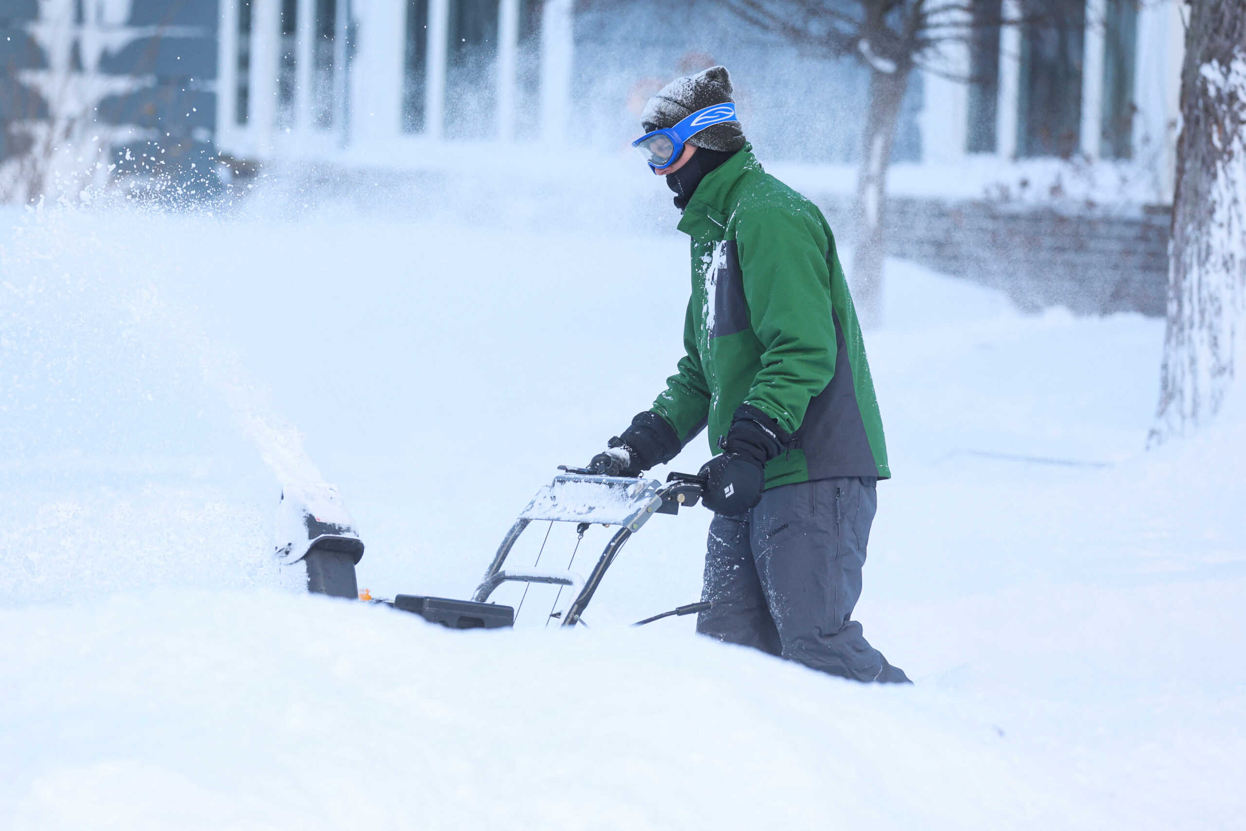 A man clears snow from his driveway following a winter storm that hit the Buffalo region in Amherst, New York, U.S., December 25, 2022.  REUTERS