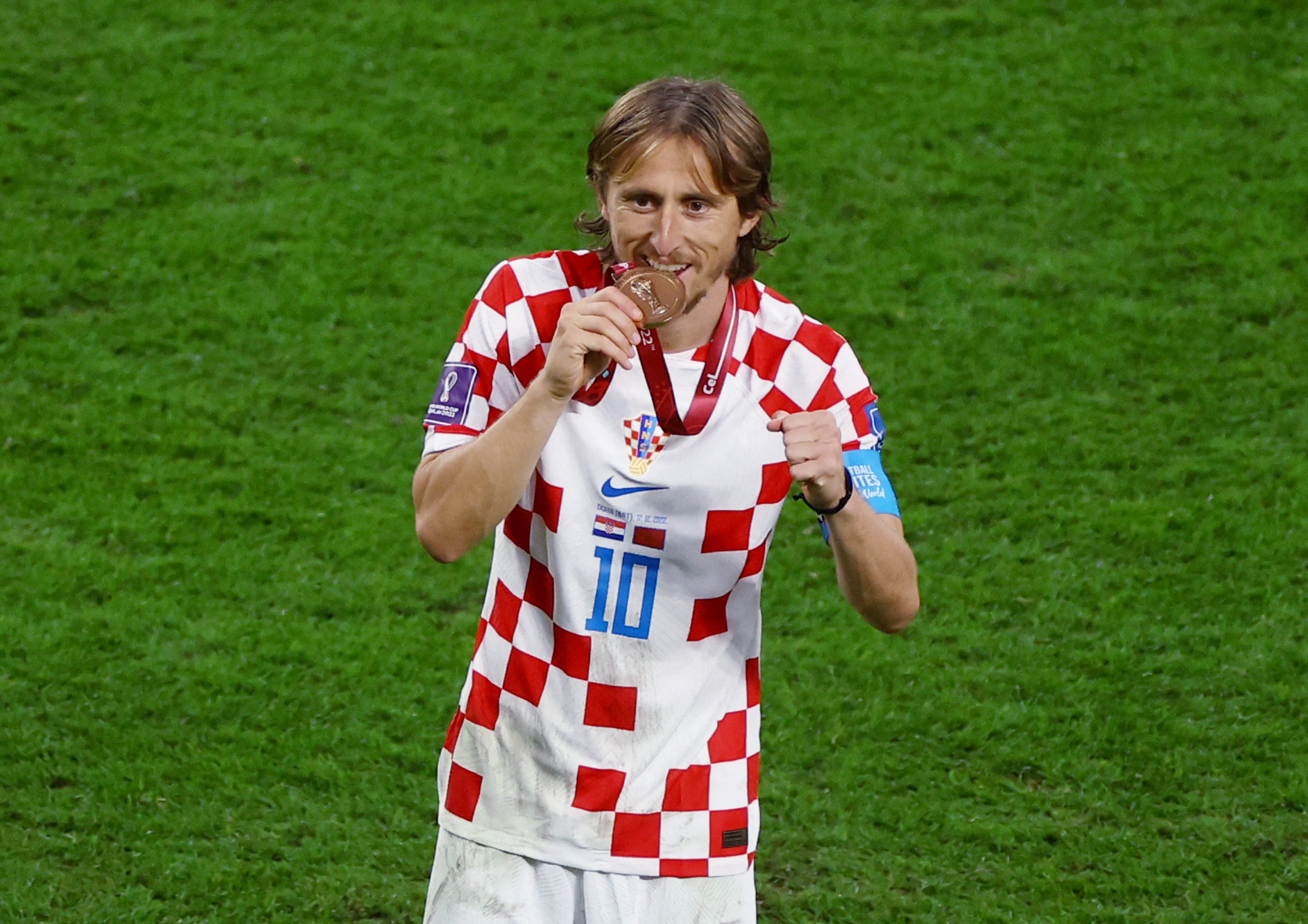 Soccer Football - FIFA World Cup Qatar 2022 - Third-Place Playoff - Croatia v Morocco - Khalifa International Stadium, Doha, Qatar - December 17, 2022 Croatia's Luka Modric bites his medal as he celebrates Croatia finishing in third place REUTERS