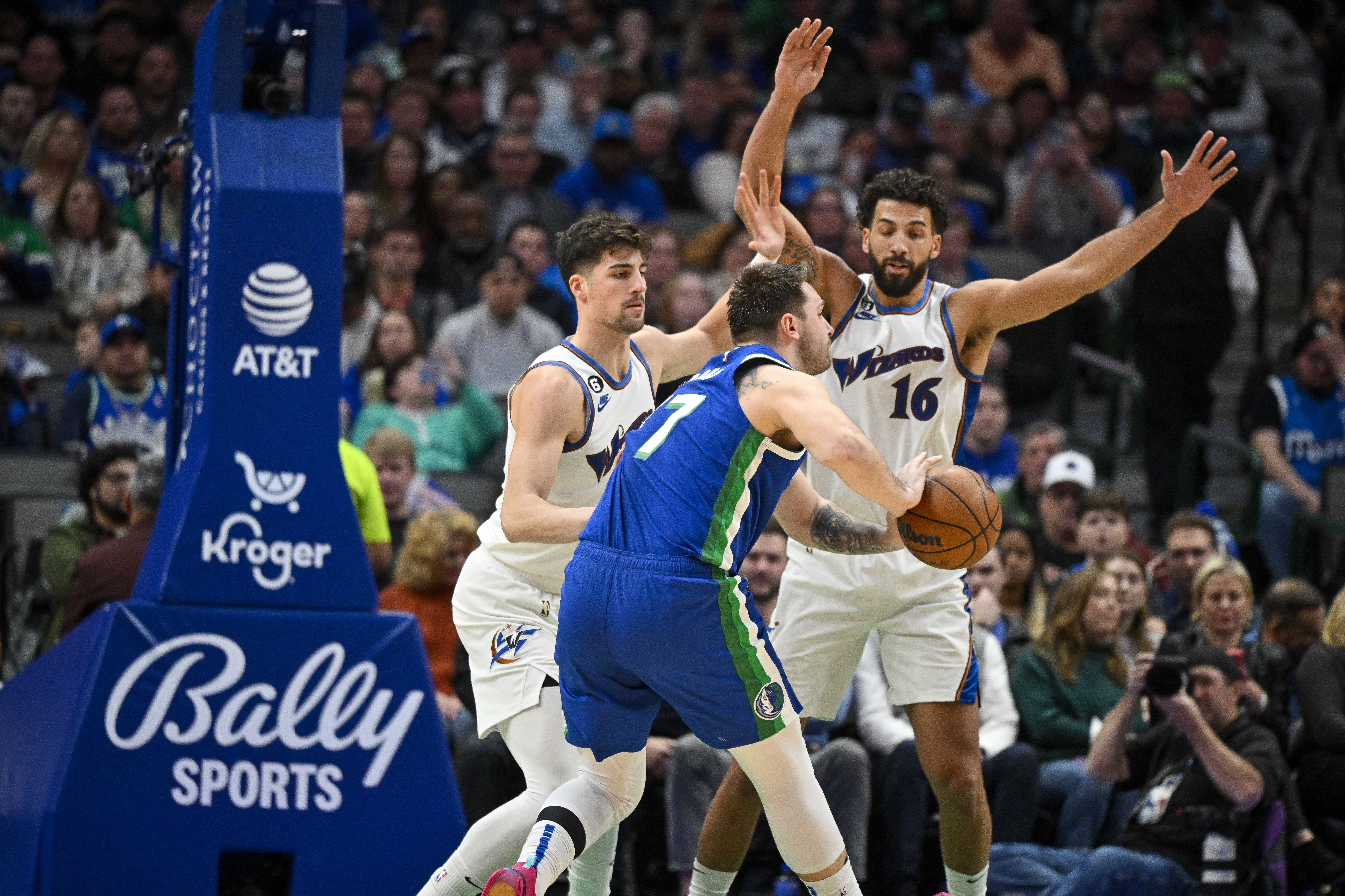 Jan 24, 2023; Dallas, Texas, USA; Dallas Mavericks guard Luka Doncic (77) looks to move the ball past Washington Wizards forward Deni Avdija (9) and forward Anthony Gill (16) during the second half at the American Airlines Center. Mandatory Credit: Jerome Miron-USA TODAY Sports