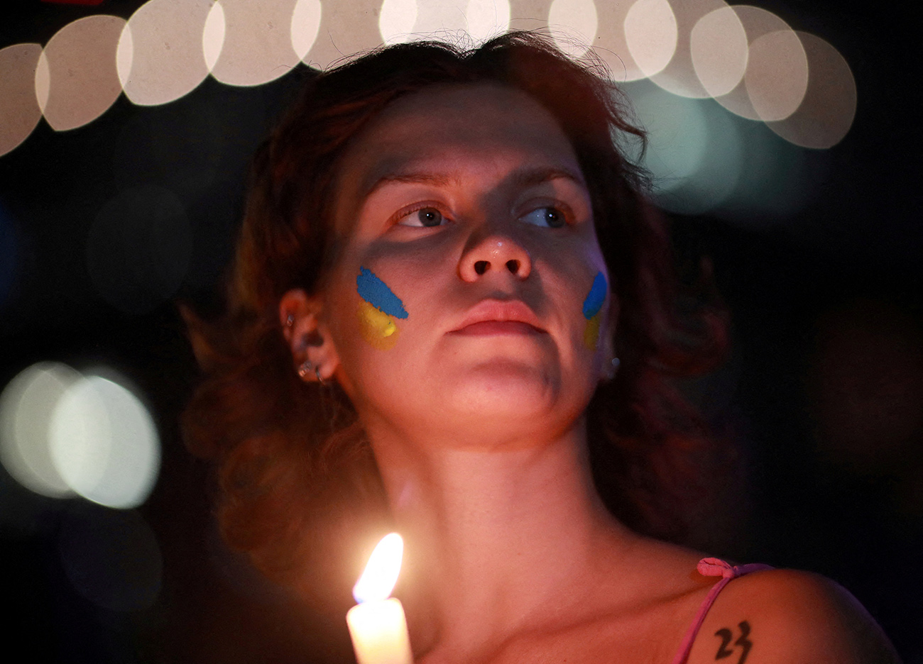 A woman holds a candle in a protest held by Ukrainian citizens living in Mexico and demonstrators, to mark the first anniversary of Russia's invasion of Ukraine, at the Angel of Independence monument in Mexico City, Mexico February 24, 2023. REUTERS