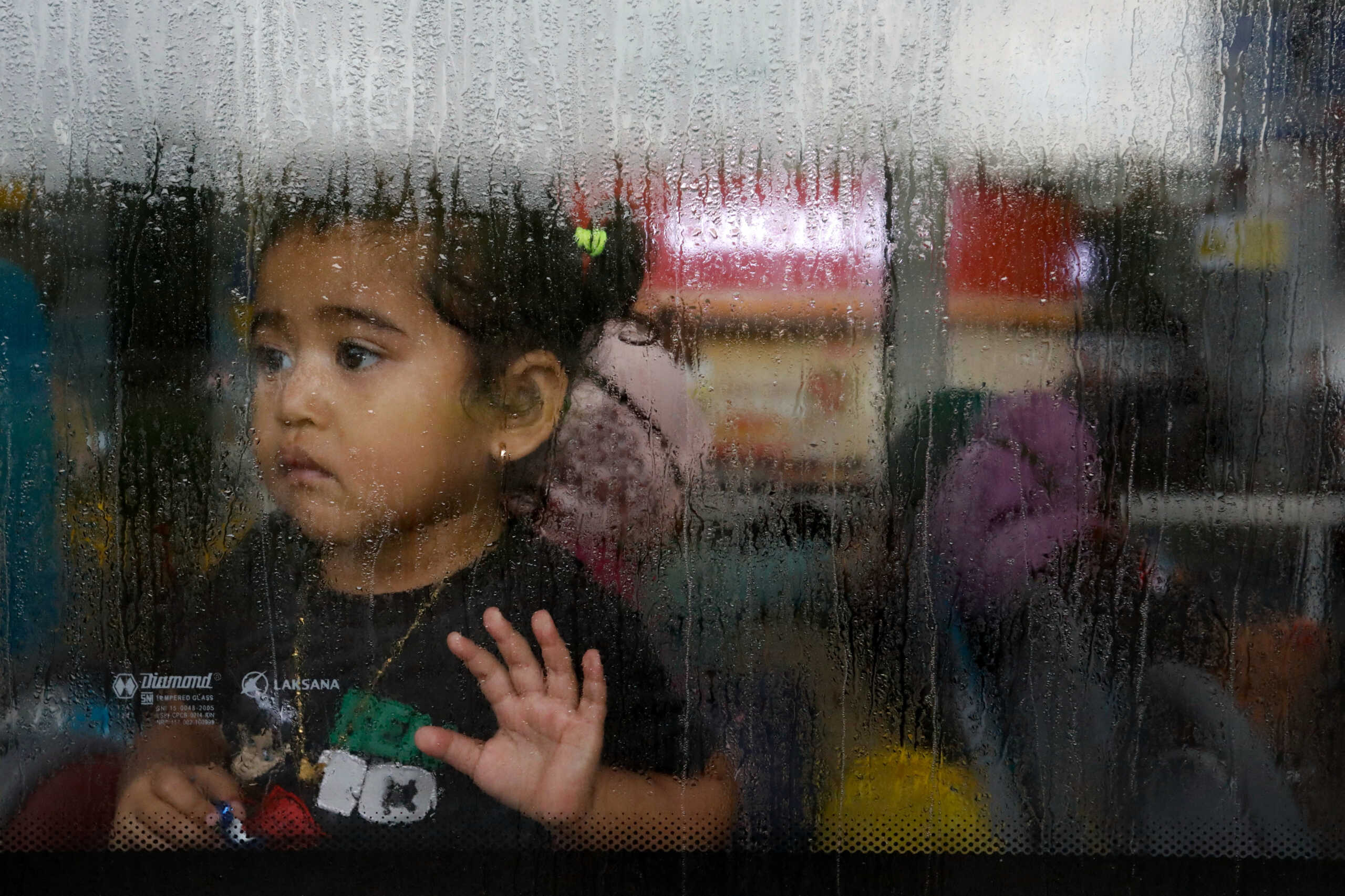 A girl evacuated from Sudan looks through the window of a bus after she arrives at the Soekarno-Hatta Airport in Tangerang, on the outskirts of Jakarta, Indonesia, April 28, 2023. REUTERS