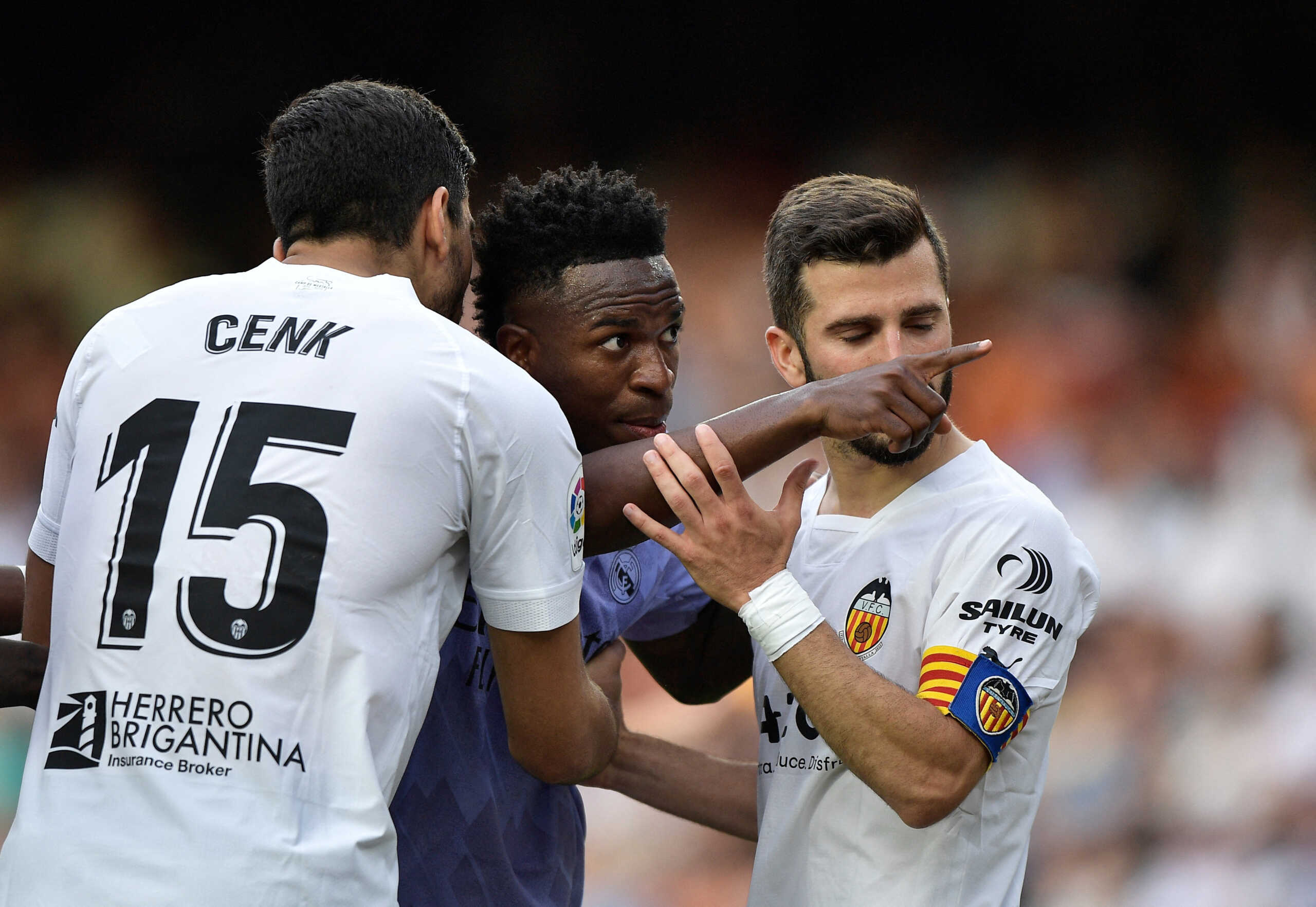 Soccer Football - LaLiga - Valencia v Real Madrid - Mestalla, Valencia, Spain - May 21, 2023 Real Madrid's Vinicius Junior gestures towards a fan as Valencia's Jose Gaya and Cenk Ozkacar attempt to restrain him REUTERS