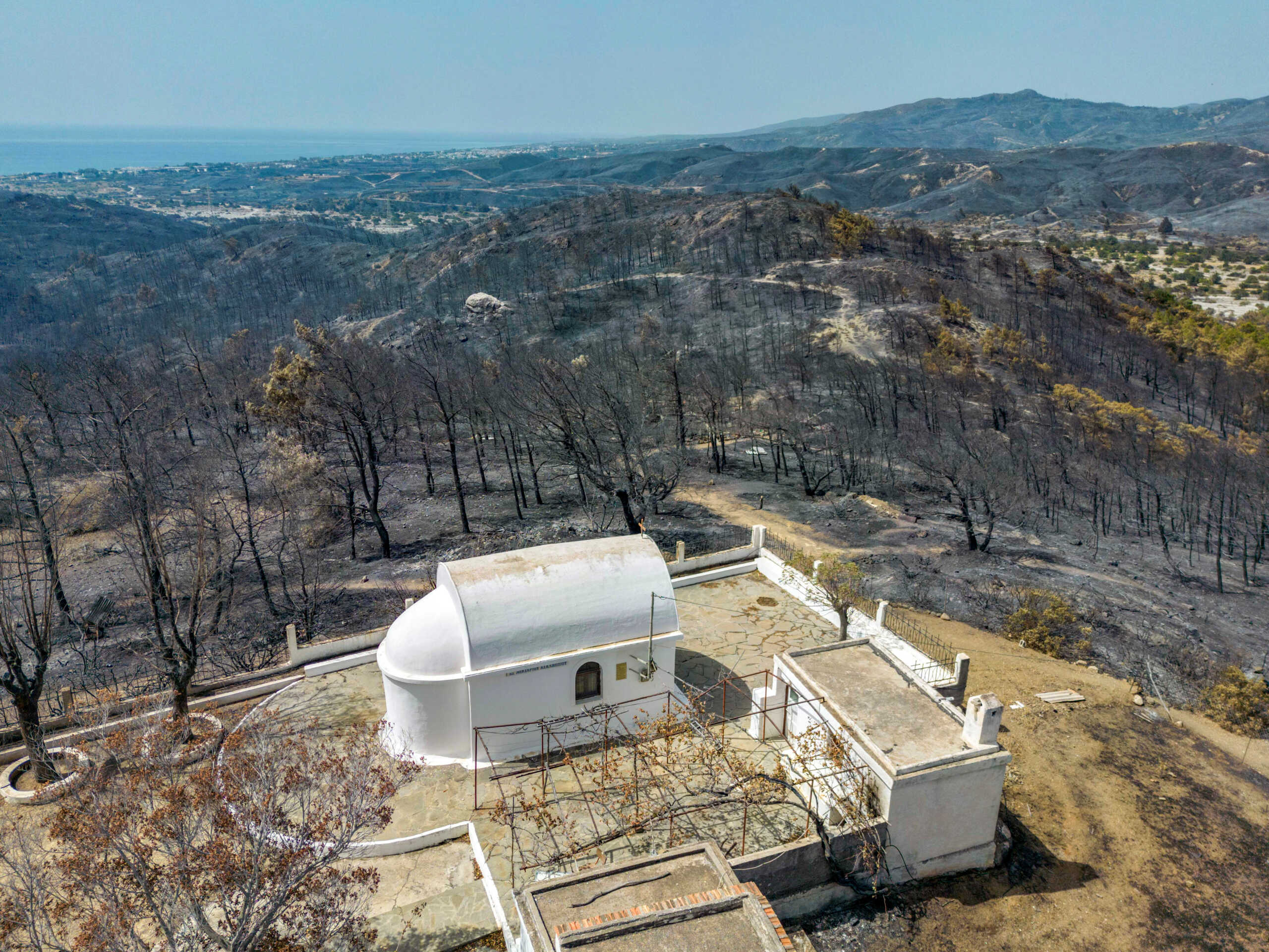 An aerial view of a church among charred trees, as a wildfire burns on the island of Rhodes, Greece, July 27, 2023. REUTERS