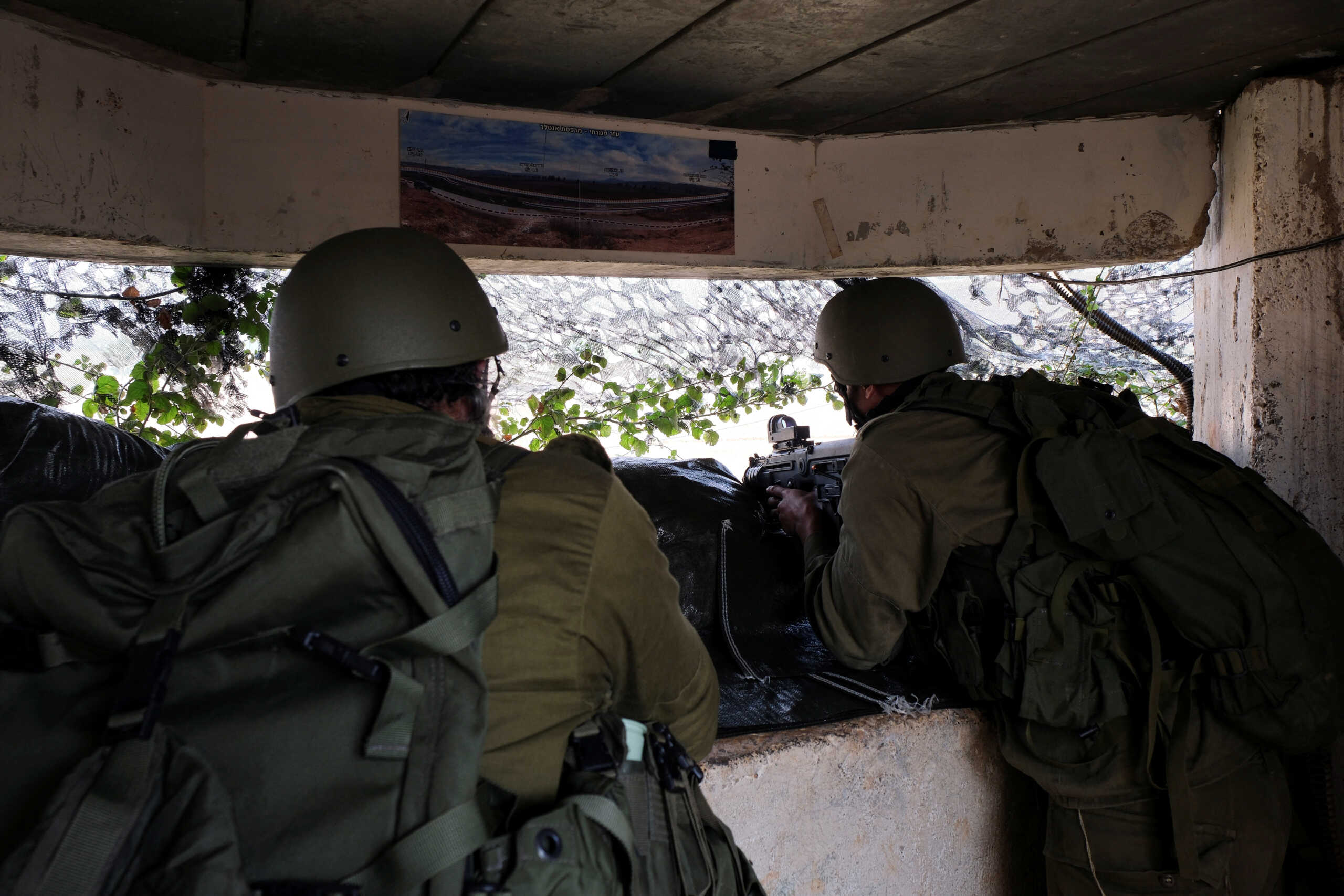 Israeli soldiers look out at Lebanon from the Israeli side of Israel's border with Lebanon in northern Israel, October 8, 2023. REUTERS