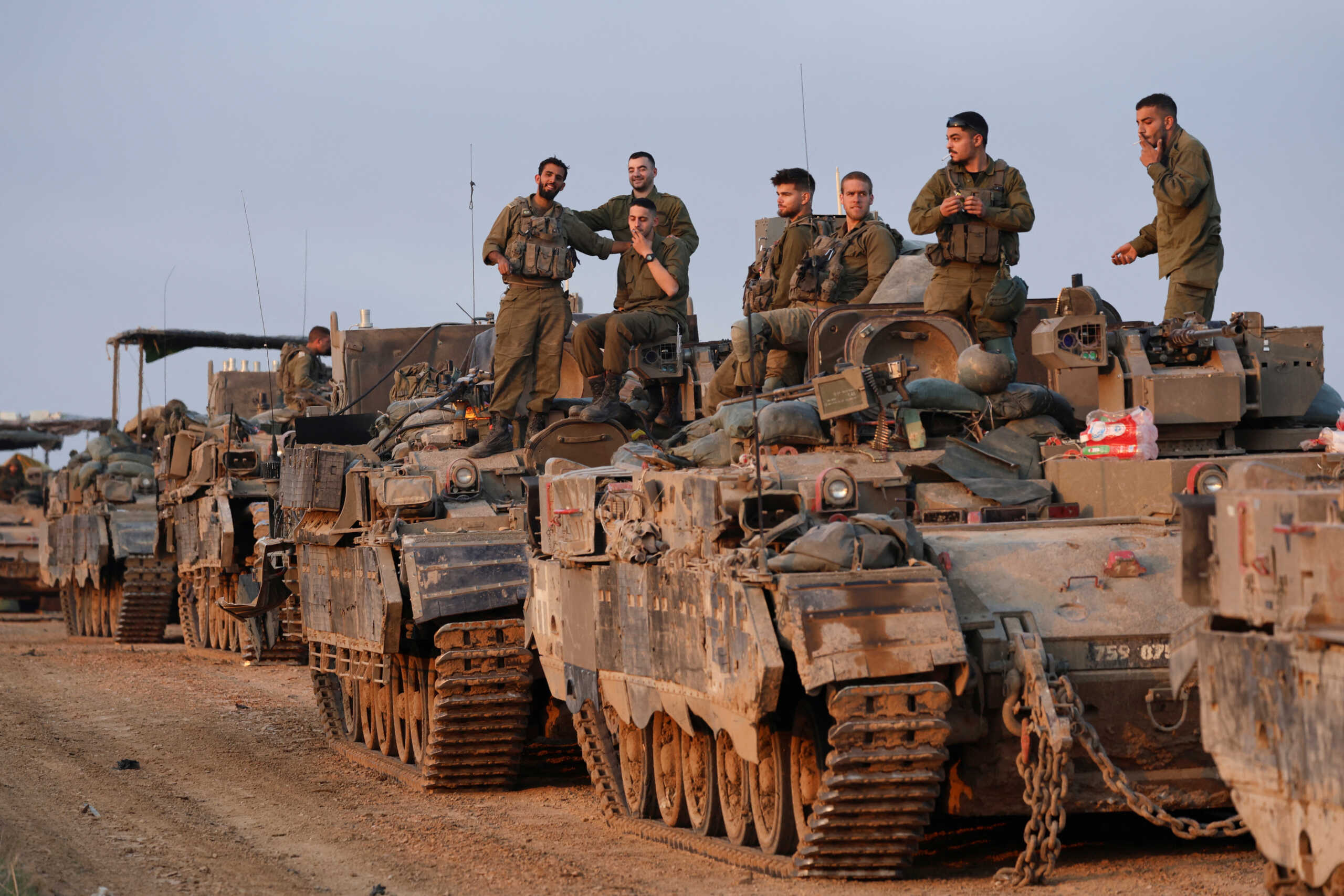 Israeli soldiers stand on armoured personnel carriers (APCs), amid the conflict between Israel and the Palestinian Islamist group Hamas, near the Israel-Gaza border, in southern Israel, December 25, 2023. REUTERS