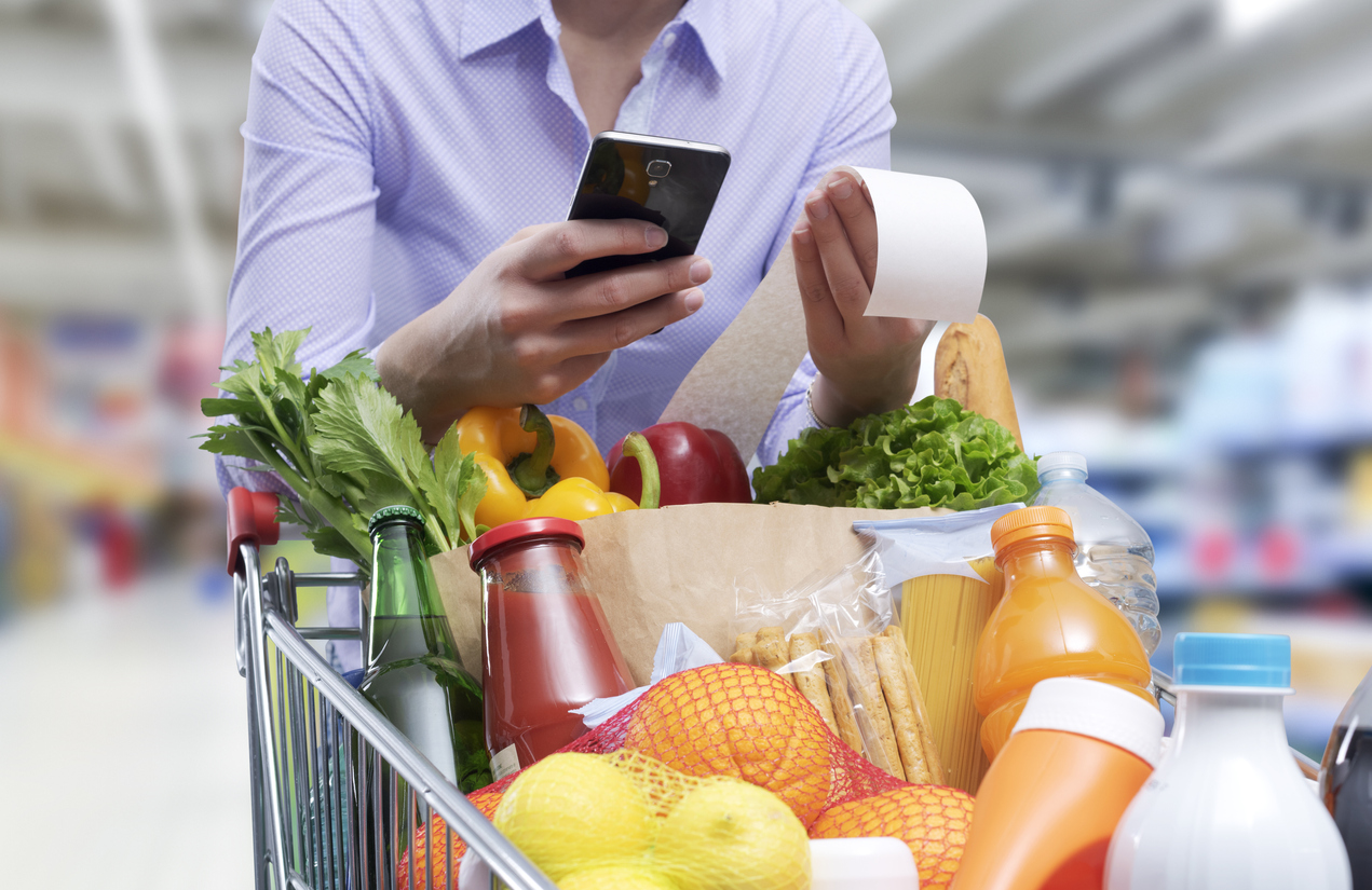 Woman checking the grocery receipt using her smartphone