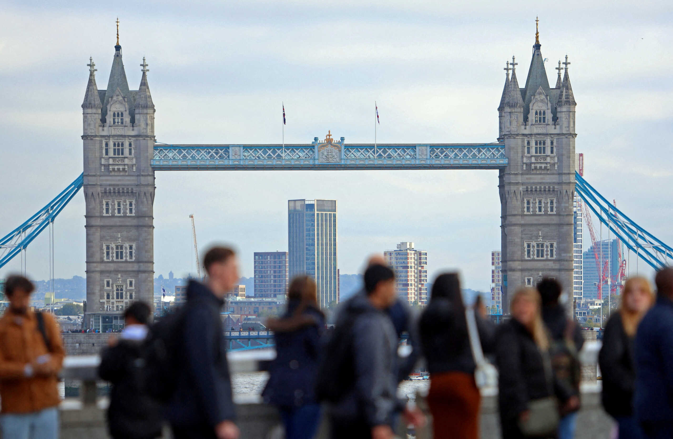 FILE PHOTO: People walk over London Bridge looking at a view of Tower Bridge in the City of London financial district in London, Britain, October 25, 2023. REUTERS